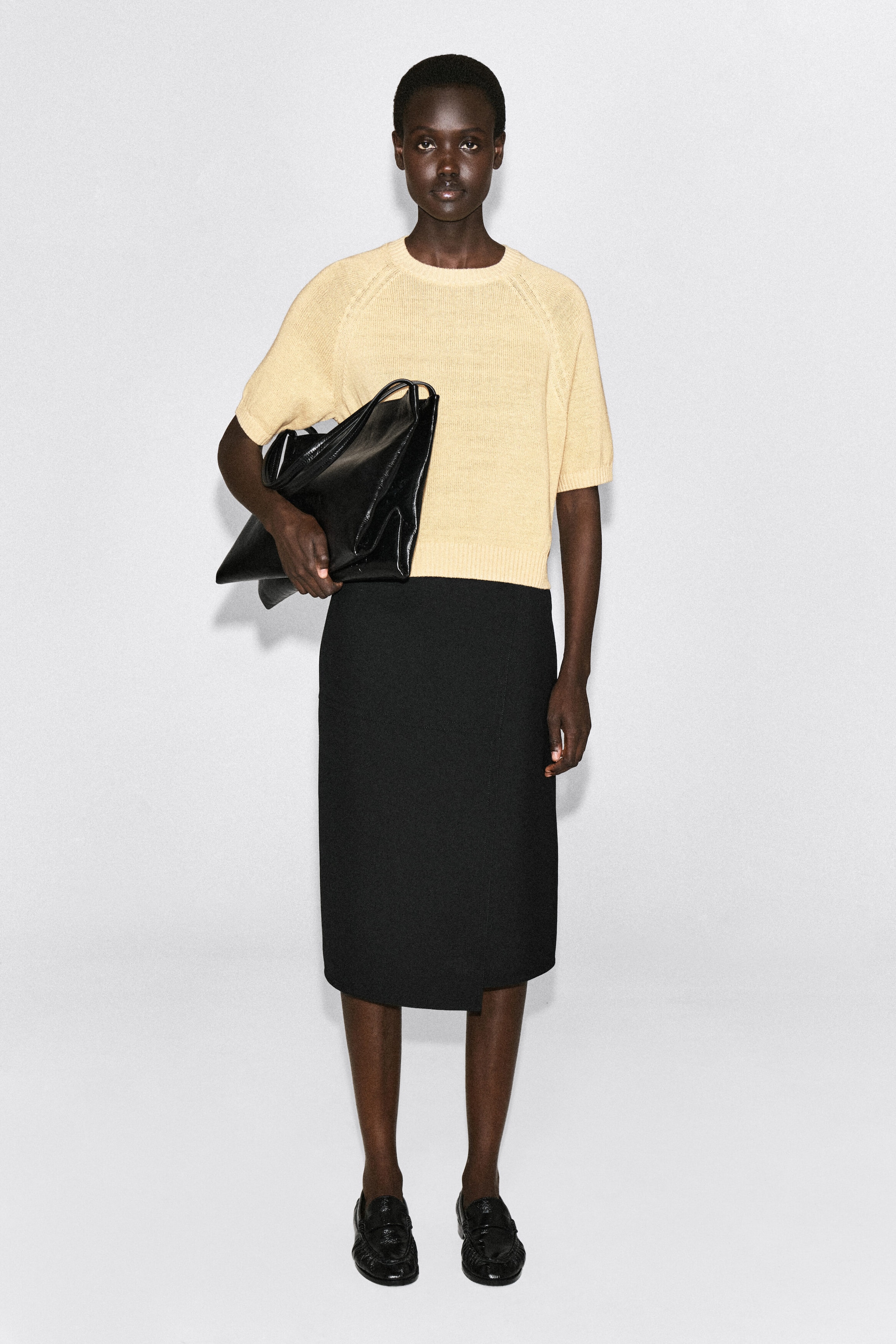 The shrunken knitted linen T-shirt in pale yellow is facing the front, showcasing its crew neckline, short raglan sleeves, and ribbed detailing on the collar, cuffs, and hem. The lightweight, textured knit is displaying a slightly cropped, shrunken fit. The shrunken knitted linen T-shirt in pale yellow is facing the front, showcasing its crew neckline, short raglan sleeves, and ribbed detailing on the collar, cuffs, and hem. The lightweight, textured knit is displaying a slightly cropped, shrunken fit.