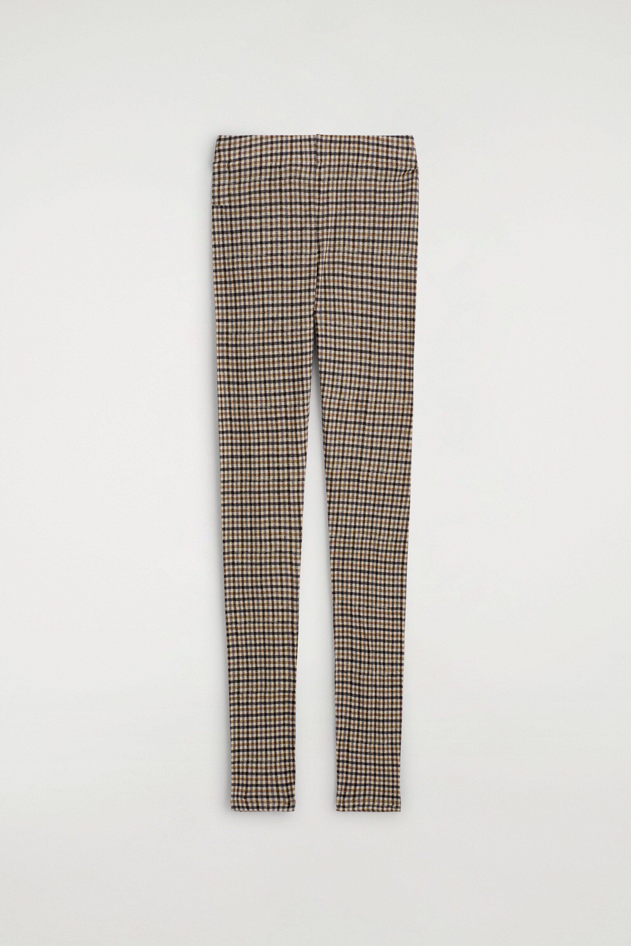 Agrandir l'image: Une paire de leggings ajustés est posée à plat, face vers l'avant, affichant un motif à carreaux marron, noir et beige clair sur son tissu en tricot. Une ceinture élastiquée est visible en haut.
