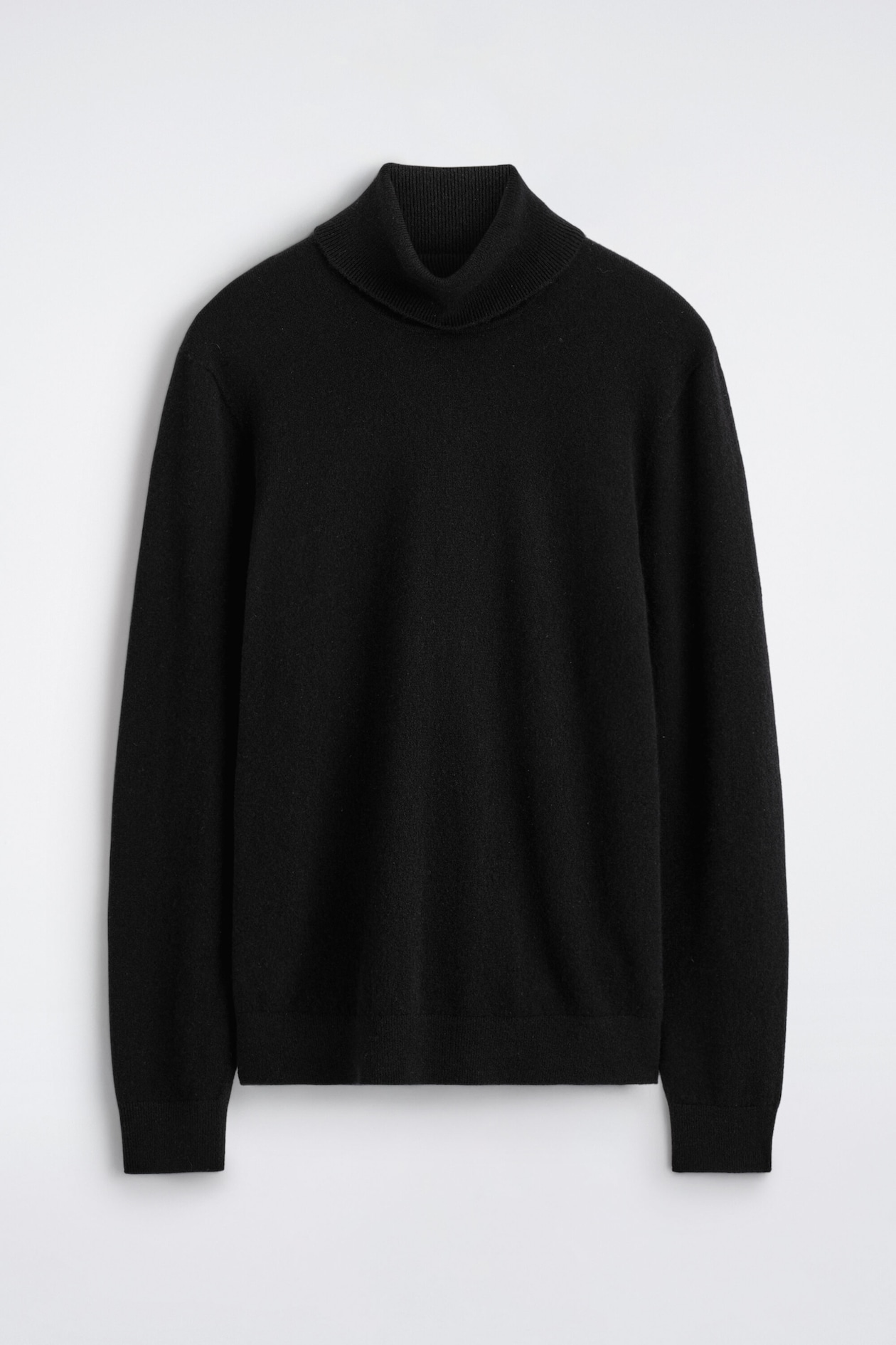 A black pure cashmere turtleneck sweater is hanging in a front-facing view, showing a ribbed turtleneck collar, long sleeves with ribbed cuffs, and a matching ribbed hem.