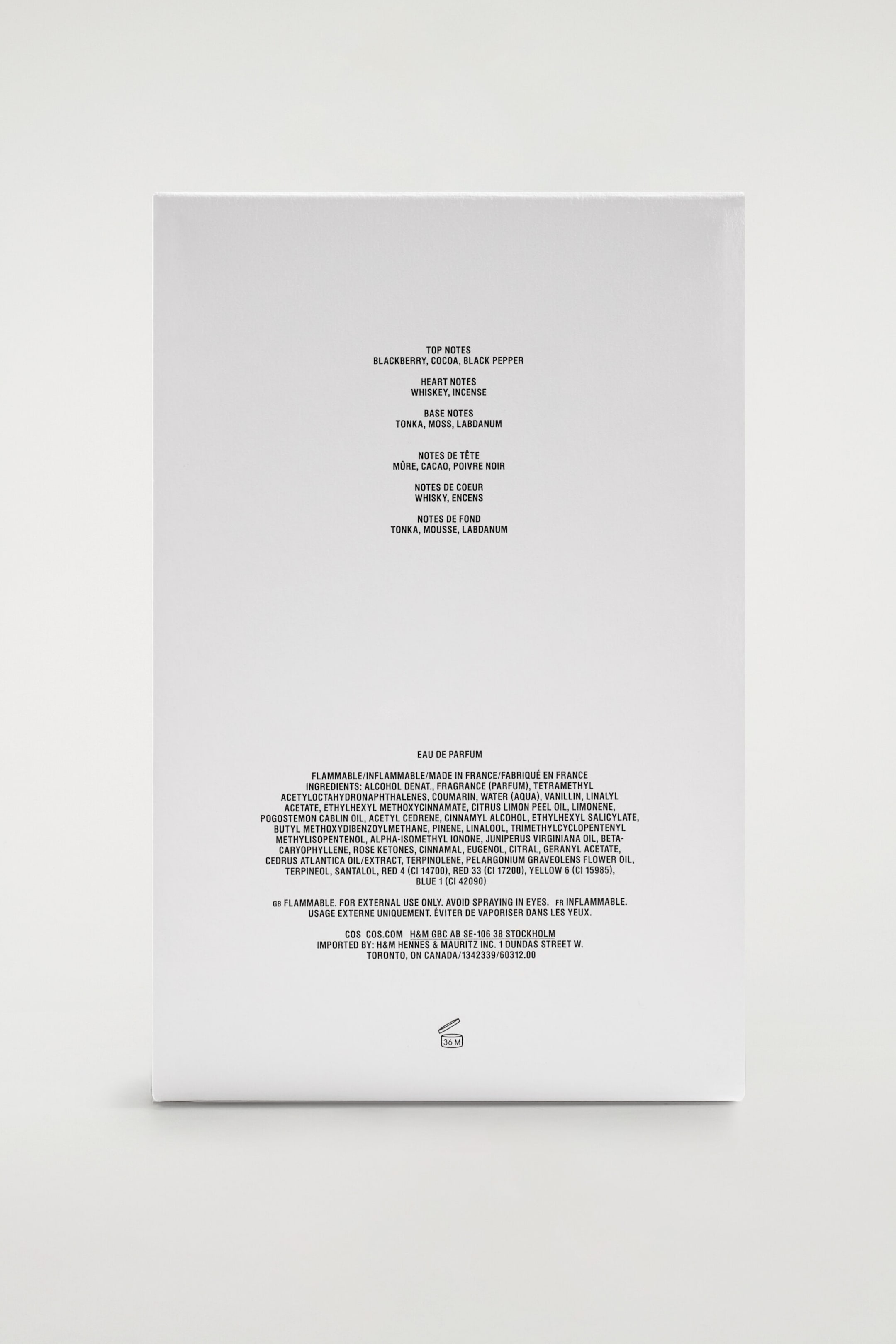 The white rectangular packaging of the COS Perfumery Eau de Parfum is shown facing the back, displaying black text listing the fragrance notes, ingredients, and manufacturing details. The white rectangular packaging of the COS Perfumery Eau de Parfum is shown facing the back, displaying black text listing the fragrance notes, ingredients, and manufacturing details.