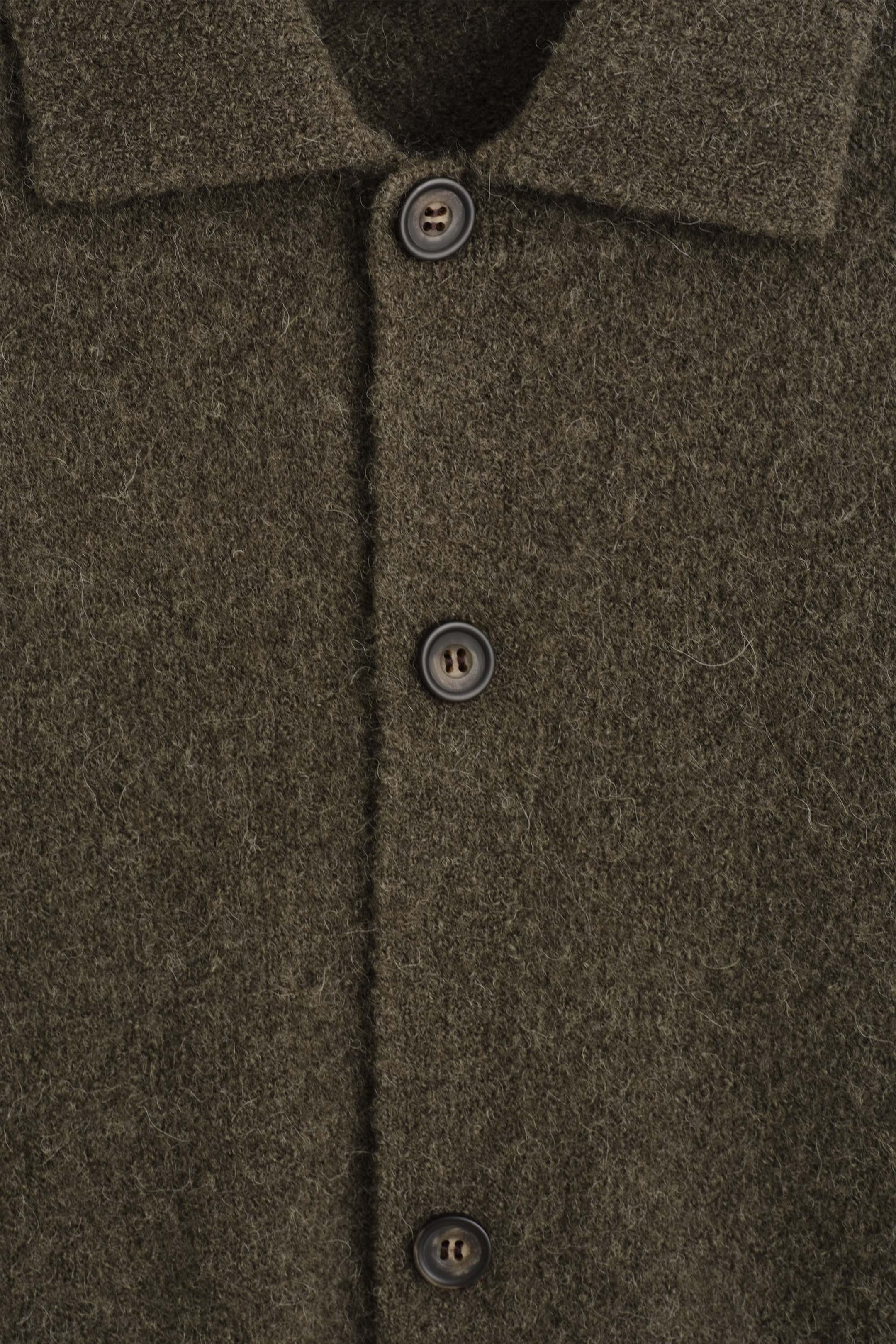 A close-up front view of the textured collared cardigan showcases its dark olive green, fuzzy wool-like fabric. The garment features a classic spread collar and a vertical button placket with dark, marbled buttons. A close-up front view of the textured collared cardigan showcases its dark olive green, fuzzy wool-like fabric. The garment features a classic spread collar and a vertical button placket with dark, marbled buttons.
