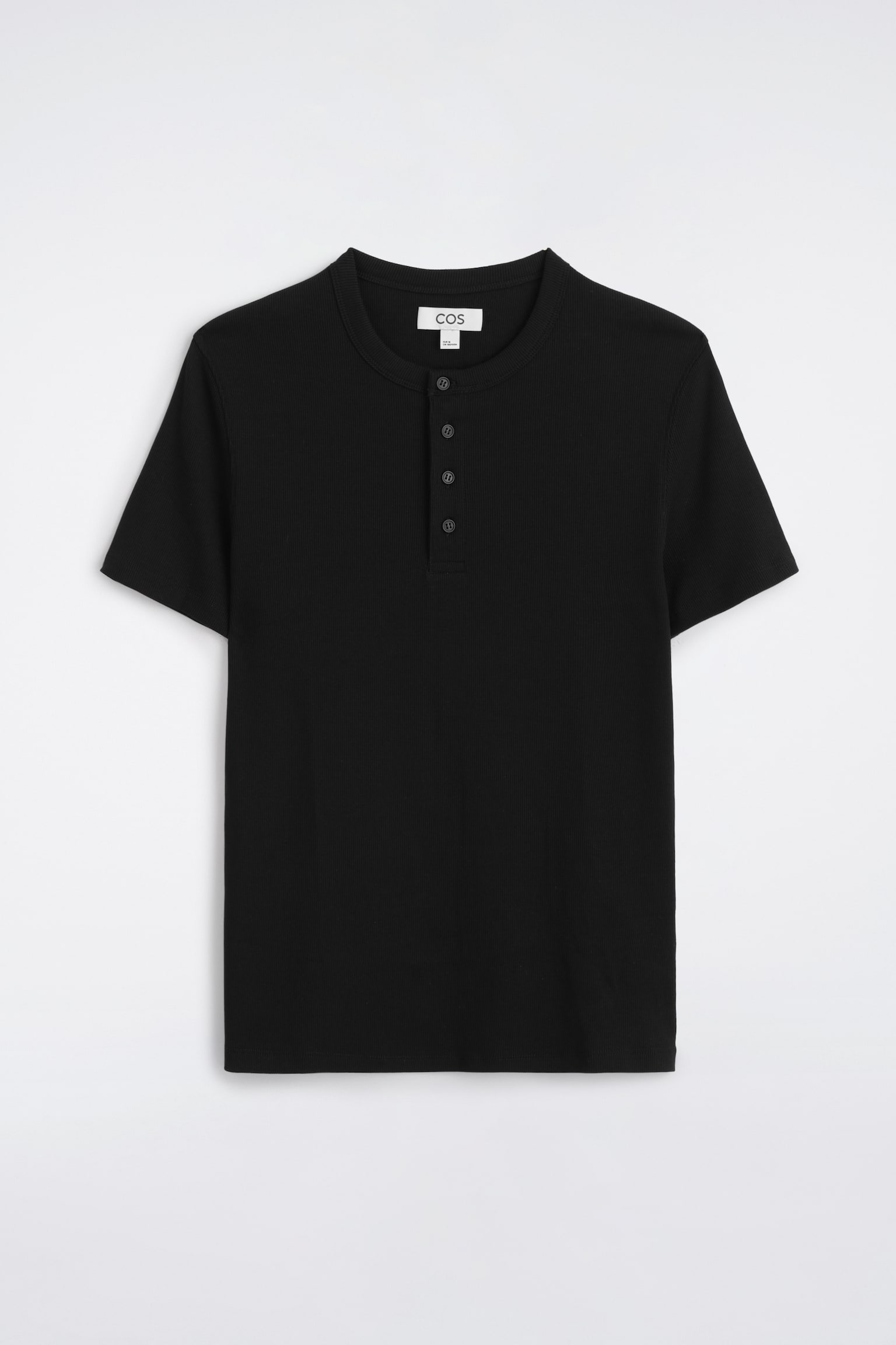 Se muestra una camiseta Henley negra entallada de canalé, vista de frente, con escote redondo y tapeta de cuatro botones, además de mangas cortas. La prenda presenta una fina textura de punto canalé en toda la superficie y un bajo limpio y recto. - 1