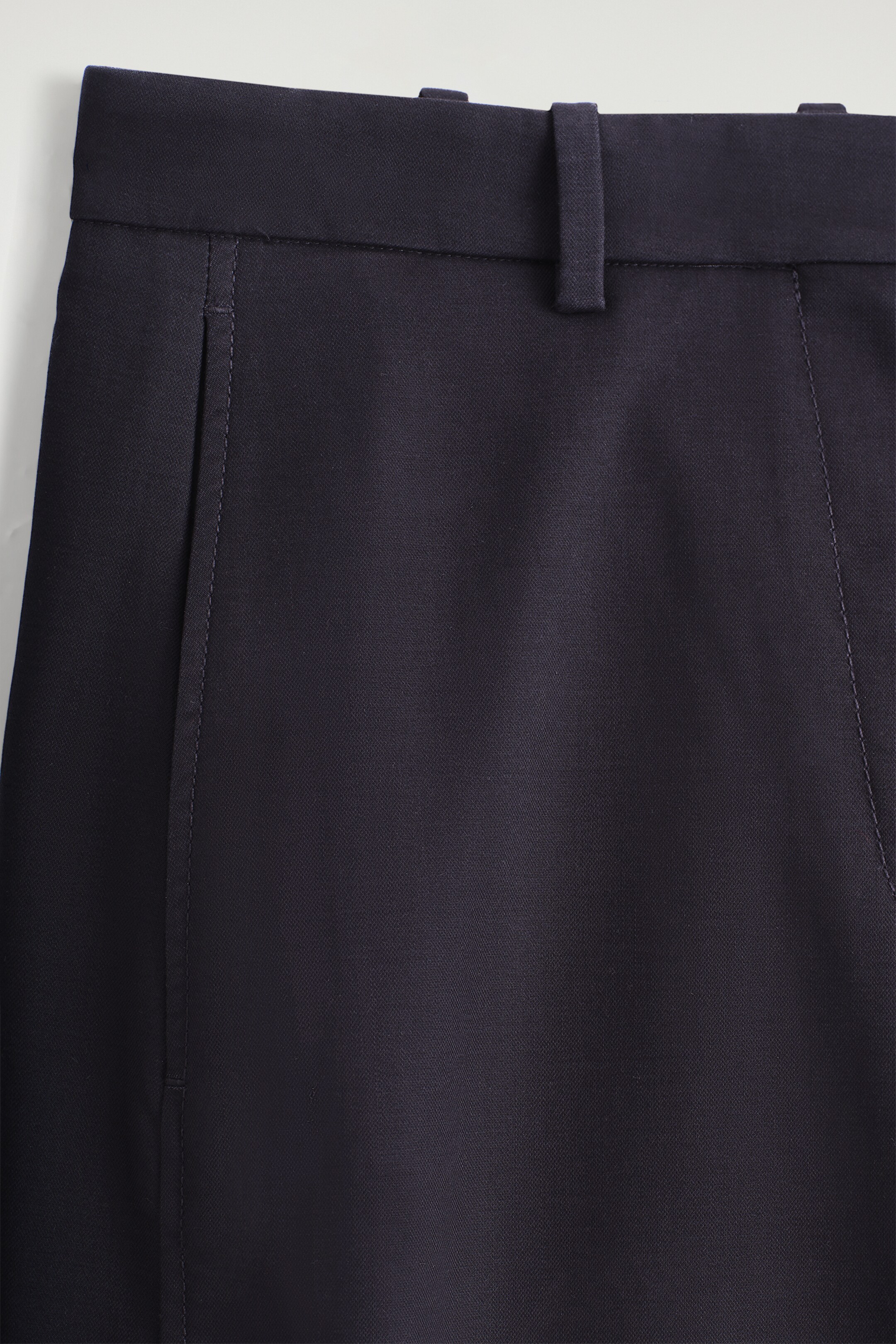 Größeres Bild anzeigen: Marineblaue Chinos aus Baumwollmischung werden von vorne gezeigt, mit einem Bund mit Gürtelschlaufen, einer Seitentasche mit sichtbaren Nähten und einer vertikal gesteppten vorderen Naht.