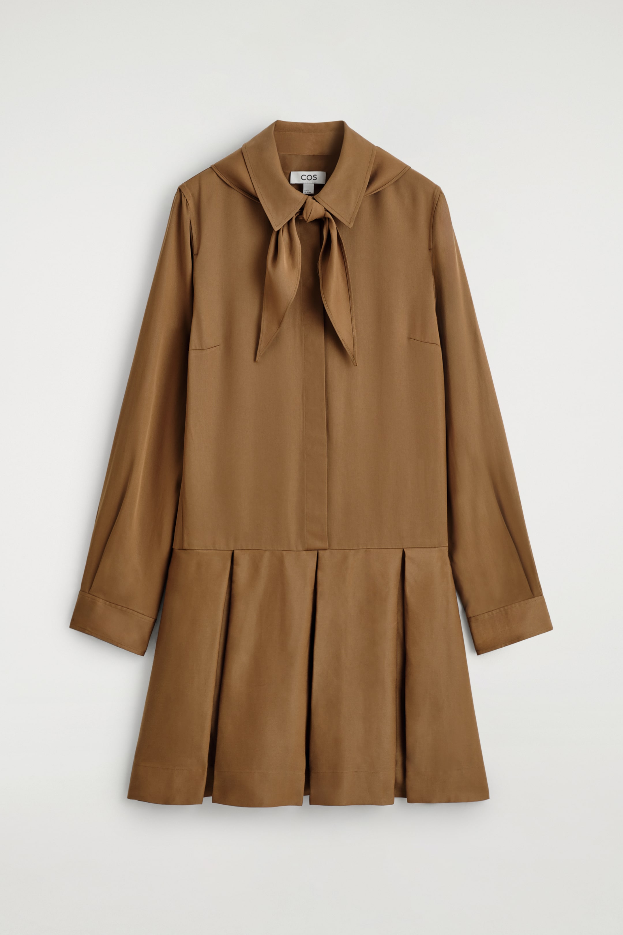 Agrandir l'image: Une robe marron chaud présente son devant, avec un col pointu orné d'un nœud noué, des manches longues avec des poignets droits, et une jupe plissée partant de la taille.