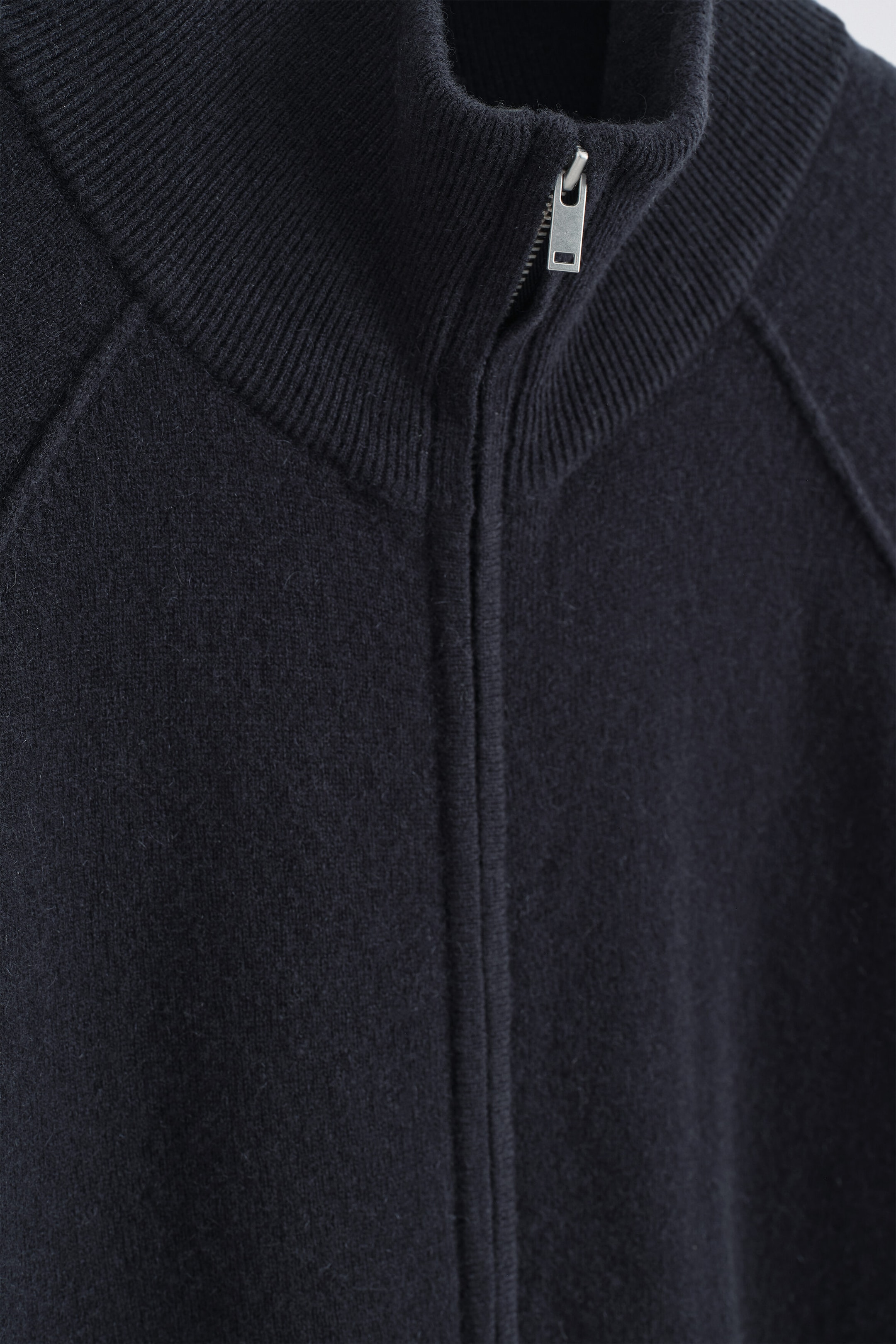 The Cashmere Funnel-Neck Zip-Up Cardigan is shown in a close-up front view, highlighting its dark navy ribbed funnel neck and a silver-tone metal zip. The cardigan features raglan shoulder seams and a soft, finely knit texture. The Cashmere Funnel-Neck Zip-Up Cardigan is shown in a close-up front view, highlighting its dark navy ribbed funnel neck and a silver-tone metal zip. The cardigan features raglan shoulder seams and a soft, finely knit texture.