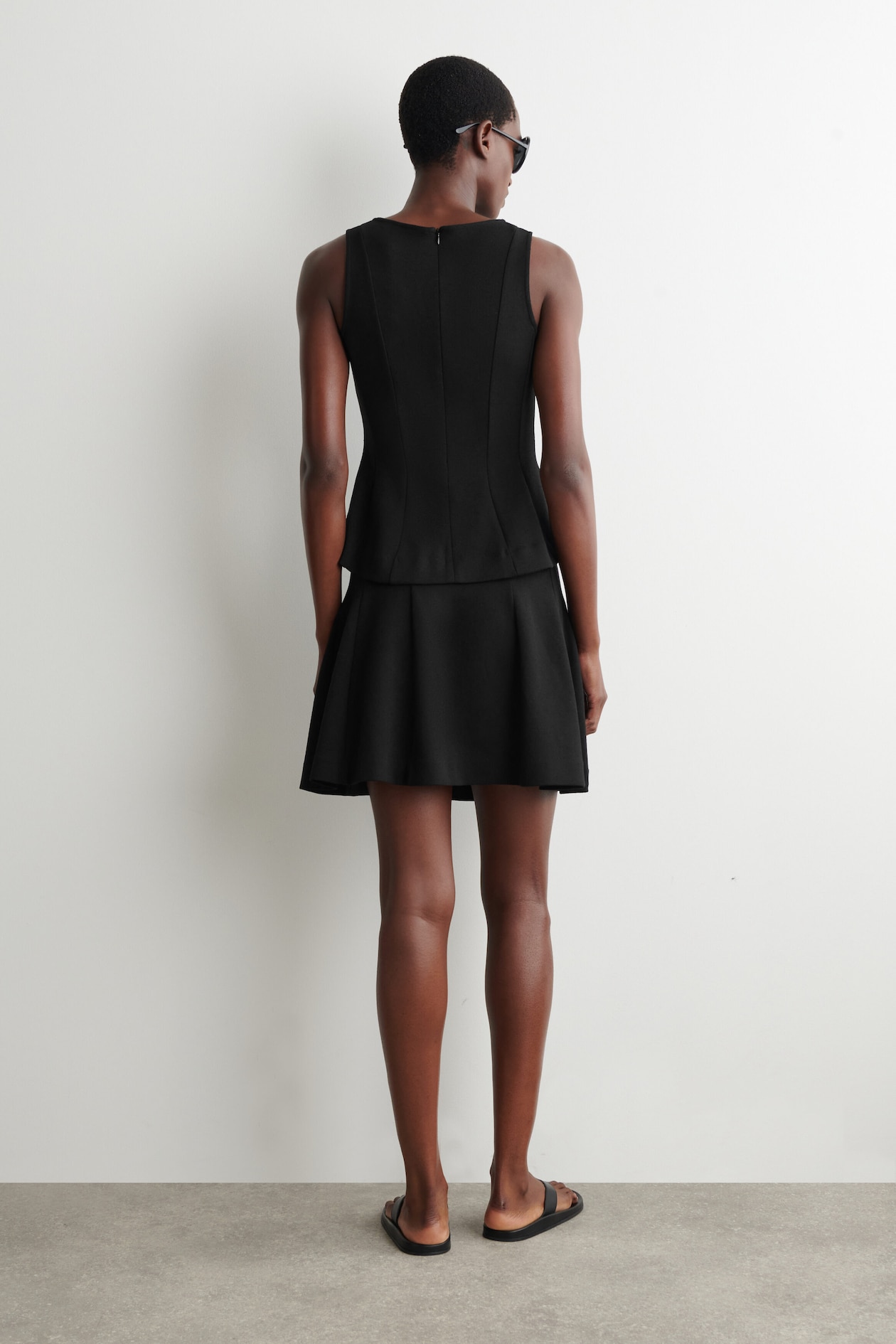 SCULPTED PANELED JERSEY MINI SKIRT — BLACK