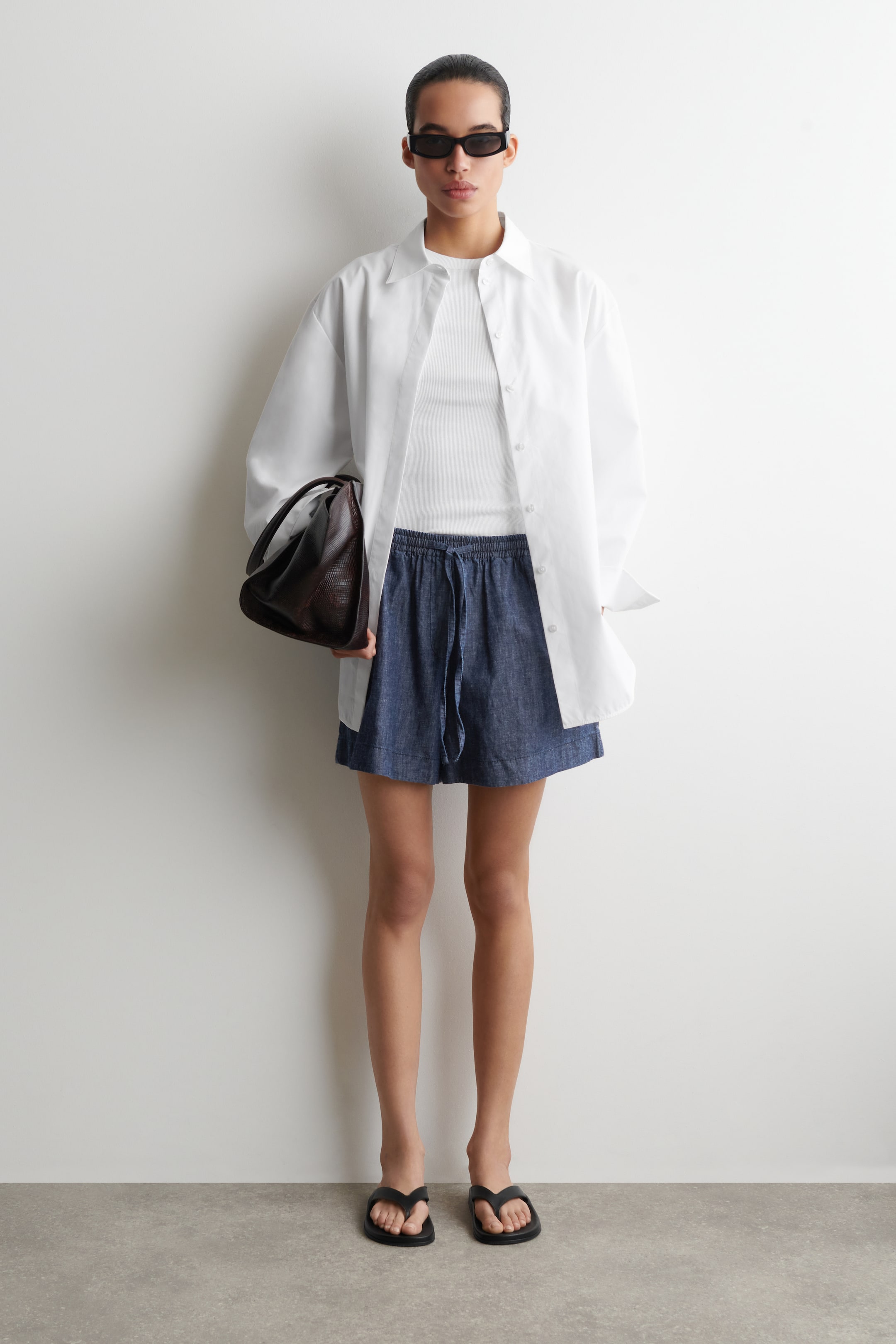 Grotere afbeelding bekijken: Blauwe chambray shorts met een elastische tailleband met trekkoord en een ontspannen pasvorm, eindigend boven de knie.