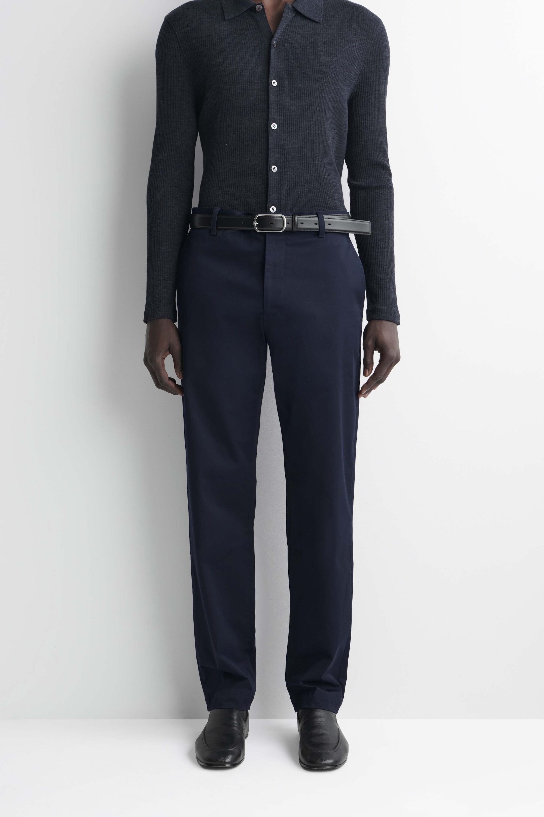 Questi chino in cotone slim fit a gamba dritta sono mostrati da una vista frontale, in una tonalità blu navy scuro, con passanti per cintura e una silhouette strutturata a gamba dritta. Sono abbinati a una cintura in pelle nera e a una camicia a maniche lunghe infilata nei pantaloni per mettere in risalto la linea pulita della vita e la vestibilità slim. Questi chino in cotone slim fit a gamba dritta sono mostrati da una vista frontale, in una tonalità blu navy scuro, con passanti per cintura e una silhouette strutturata a gamba dritta. Sono abbinati a una cintura in pelle nera e a una camicia a maniche lunghe infilata nei pantaloni per mettere in risalto la linea pulita della vita e la vestibilità slim.