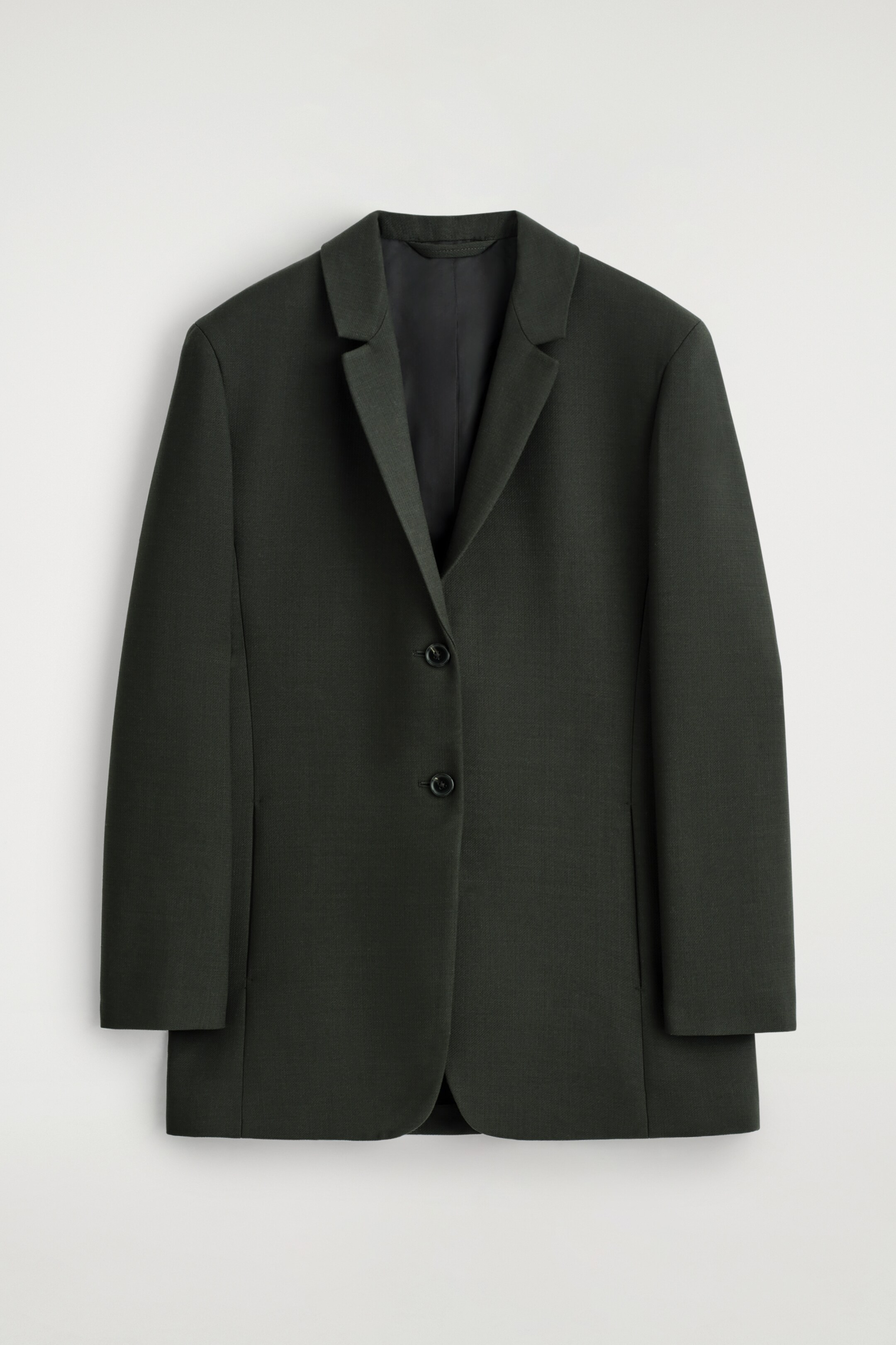 Grotere afbeelding bekijken: Een diepgroene blazer wordt van VOORAAN getoond en heeft een gestroomlijnd, lang model met inkeping revers en een enkelschalssluiting met twee zwarte knopen.