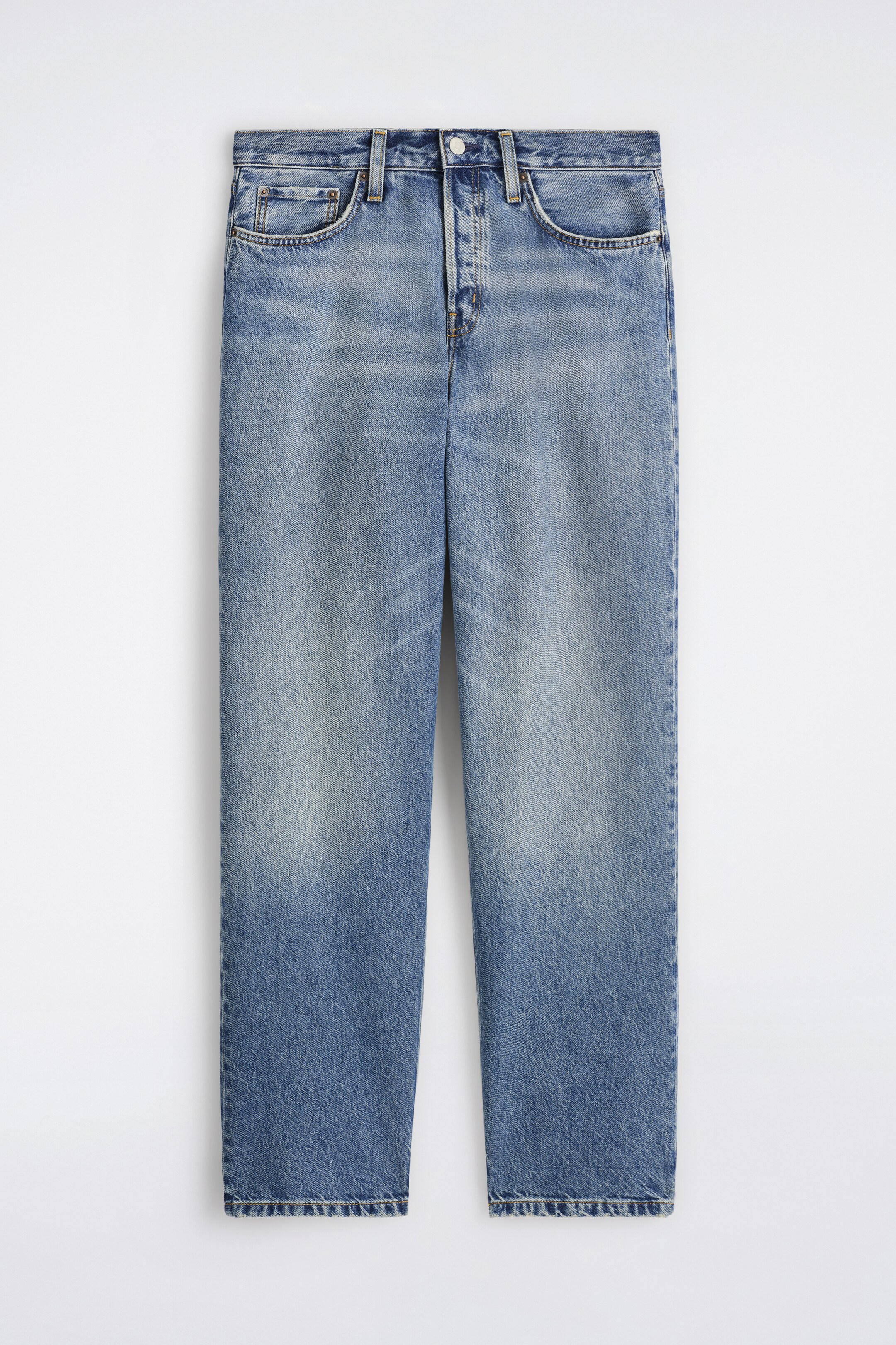 Visa större bild: Framsidan av ett par blå denimjeans visas, med en blekt tvätt som har ljusare områden på låren och mörkare fållar. Dessa jeans med raka ben är designade med en knappstängning, bältesöglor och två främre scoopfickor inklusive en myntficka.