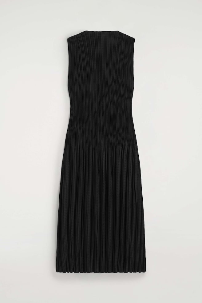 Ein schwarzes, ärmelloses Maxi-Kleid aus plissiertem Jacquard ist von vorne zu sehen und zeigt feine vertikale Falten über die gesamte, säulenförmige Silhouette. Das Kleid verfügt über einen hohen Halsausschnitt und einen strukturierten Stoff, der bis zu einem geraden Saum in Maxi-Länge fällt. - 1
