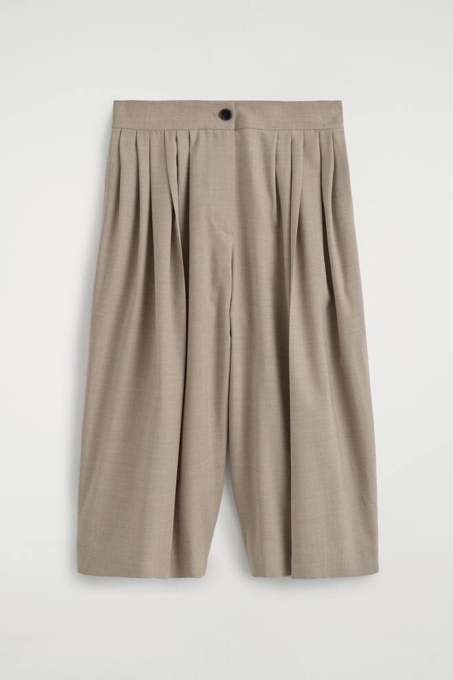Plissierte Culottes aus Wollmischung sind von vorne dargestellt und verfÃ¼gen Ã¼ber einen hoch geschnittenen Bund mit einem einzelnen dunklen Knopfverschluss und einer verdeckten Knopfleiste. Mehrere tiefe Falten laufen vom Bund nach unten und schaffen eine voluminÃ¶se, drapierte Weitbeinsilhouette in einem hellen Taupe-Ton. - 1