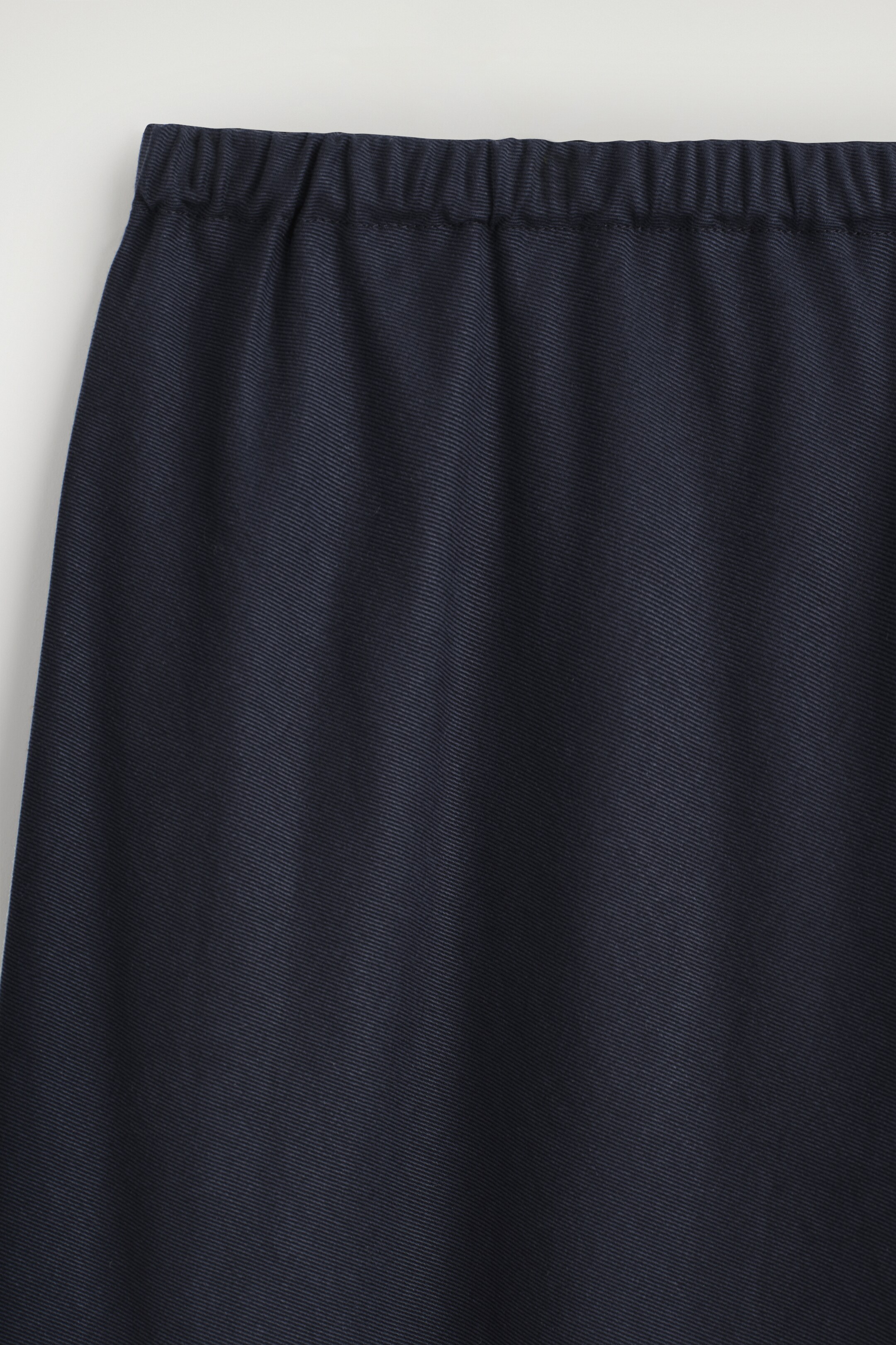 Größeres Bild anzeigen: Der obere vordere Teil der dunkelblauen Hose verfügt über einen elastischen, gerafften Bund und einen fließenden Stoff mit einem subtilen diagonalen Gewebe.