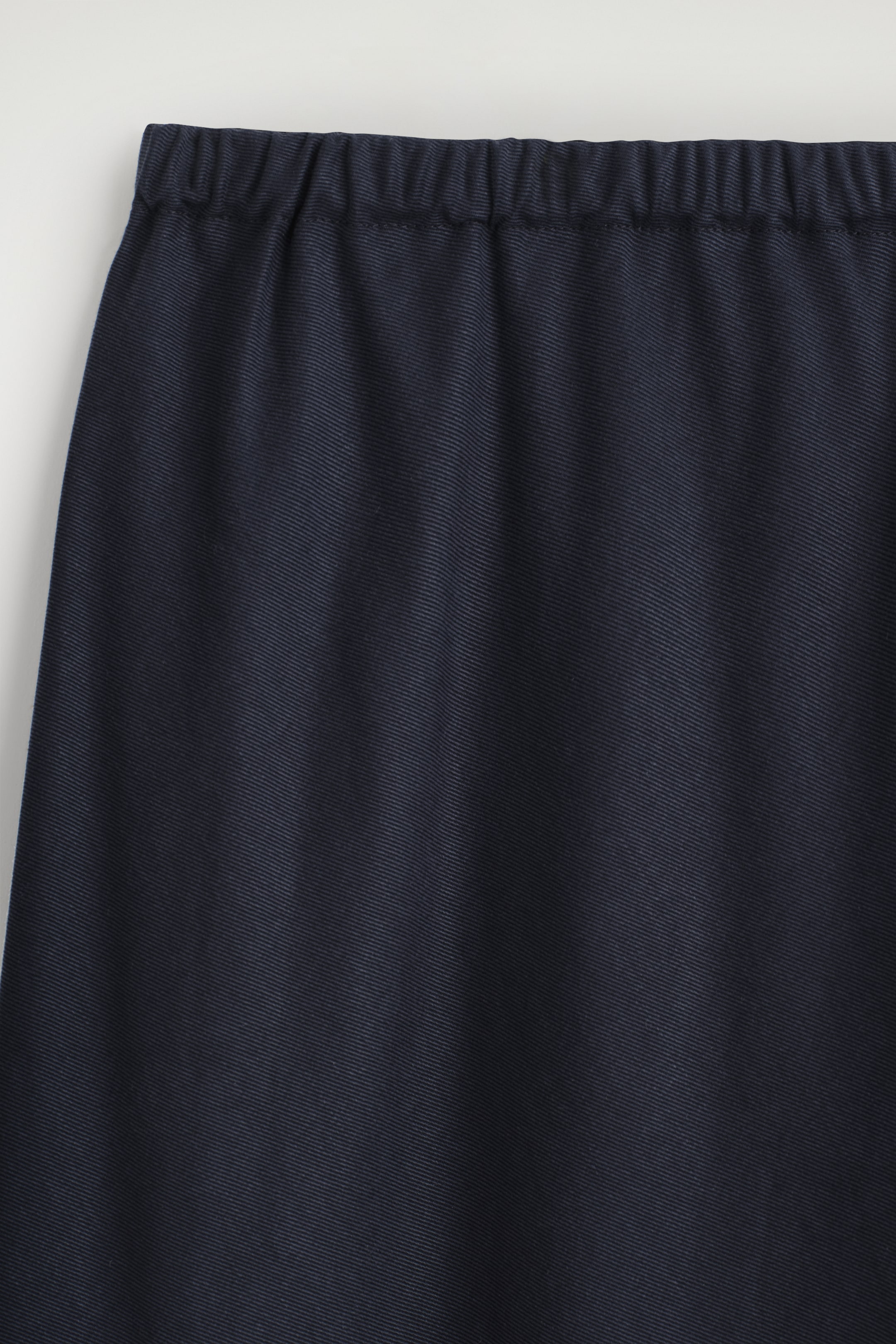 Agrandir l'image: La partie supérieure avant d'un pantalon bleu marine foncé présente une taille élastiquée et froncée, ainsi qu'un tissu fluide avec un tissage diagonal subtil.