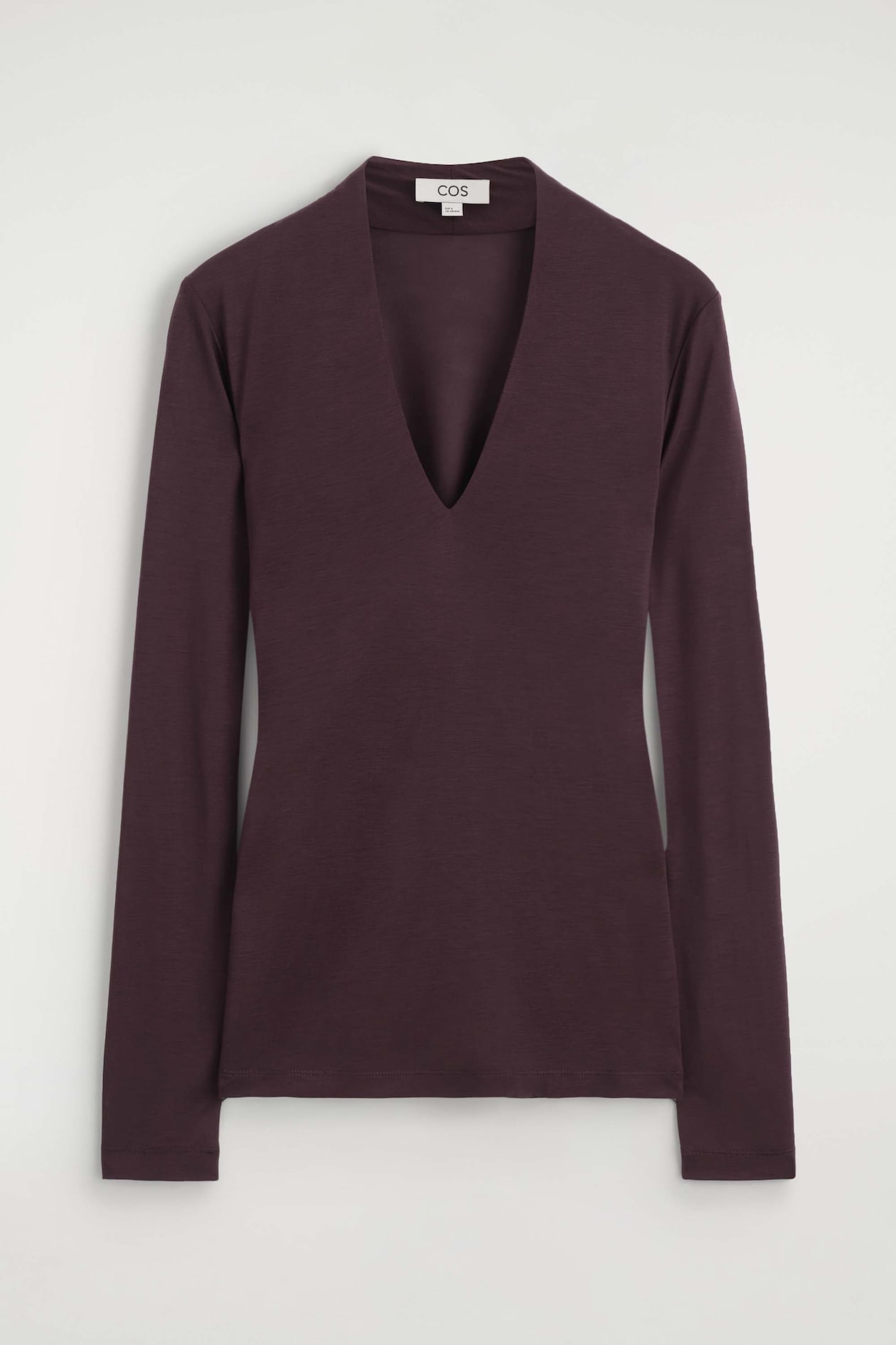 A dark plum, long-sleeved top is facing forward, showcasing a deep V-neckline, a slim-fit silhouette, and a smooth jersey texture.