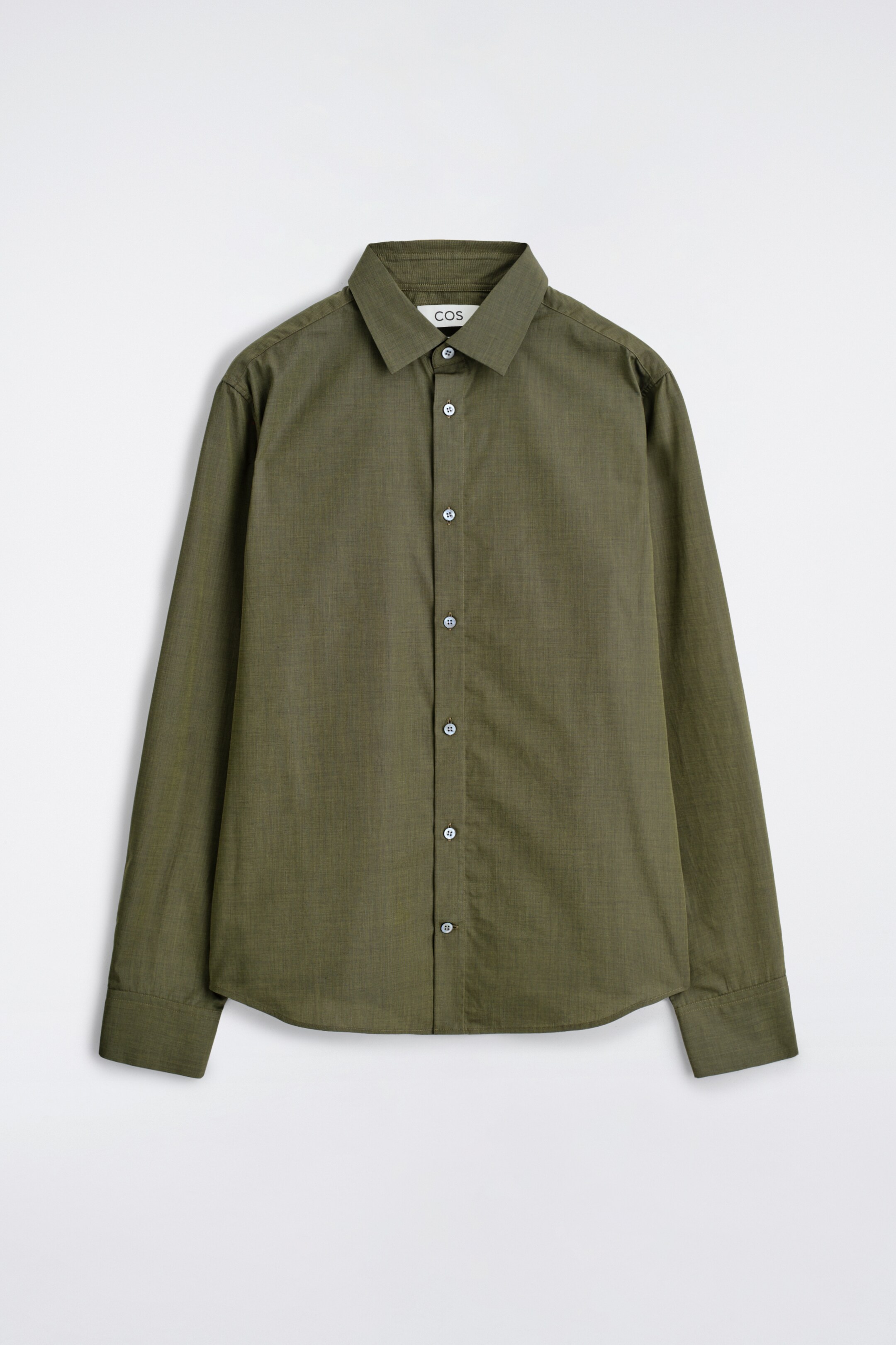 Ver imagen más grande: Una camisa verde oscuro de manga larga está de cara al FRENTE, con un tejido texturizado. Tiene un cuello en punta, una tapeta de botones en la parte delantera con botones de color claro y puños abotonados.