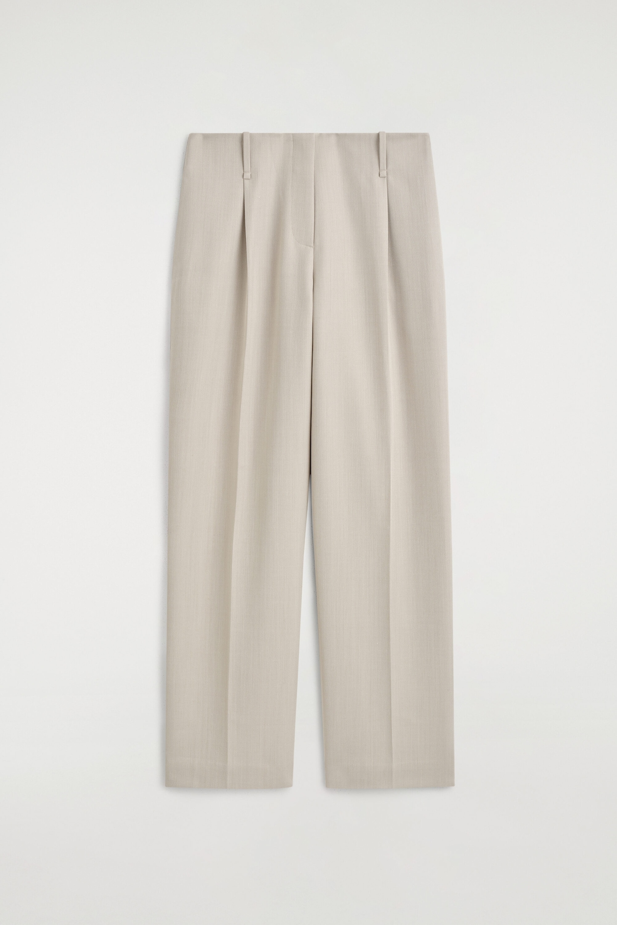 These light beige, high-waisted trousers are shown from the front, showcasing a straight-leg silhouette with sharp pressed creases running down each leg. The design features front pleating, a concealed fly closure, and subtle belt loops along the waistband.