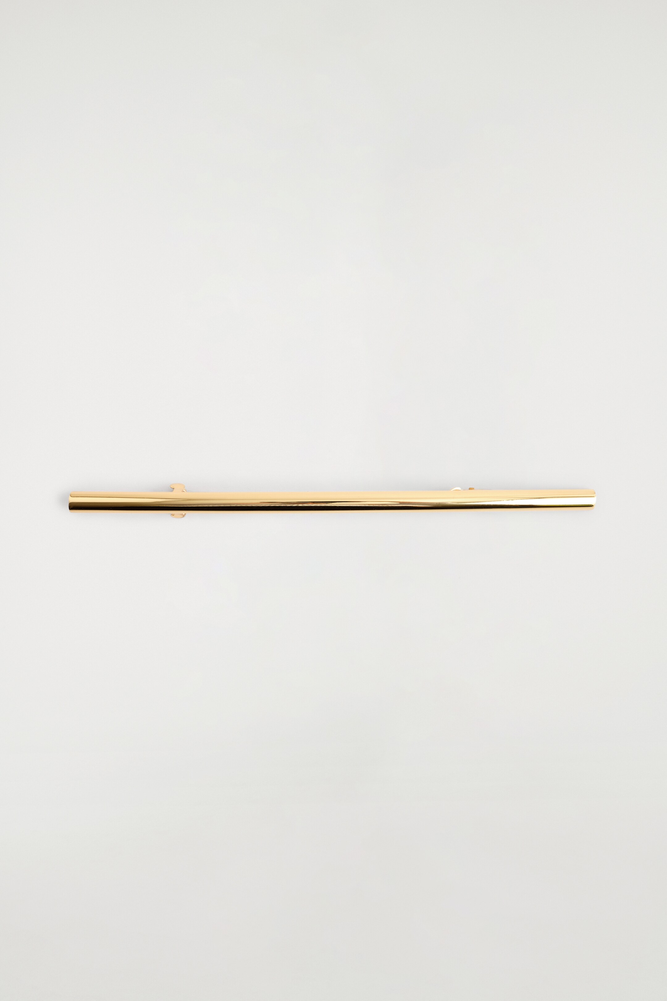 Visualizza immagine più grande: Una forcina lineare è presentata orizzontalmente, caratterizzata da una barra metallica lucida color oro. Un piccolo meccanismo di chiusura a forma di C è visibile sul lato inferiore vicino all'estremità sinistra.