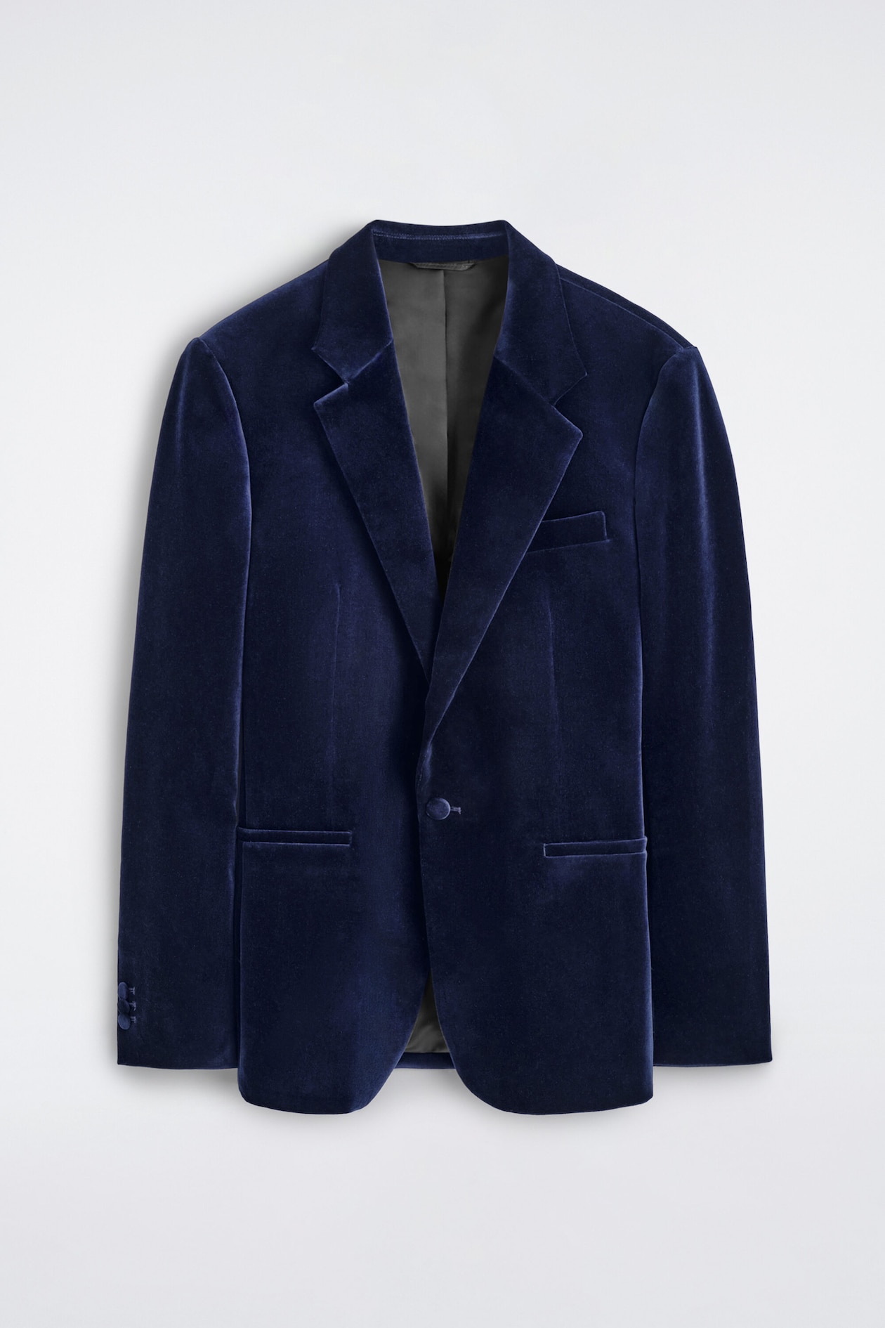 A navy blue velvet dinner jacket is shown from the front, displaying a single-breasted design with notch lapels, a single-button fastening, and front welt pockets.