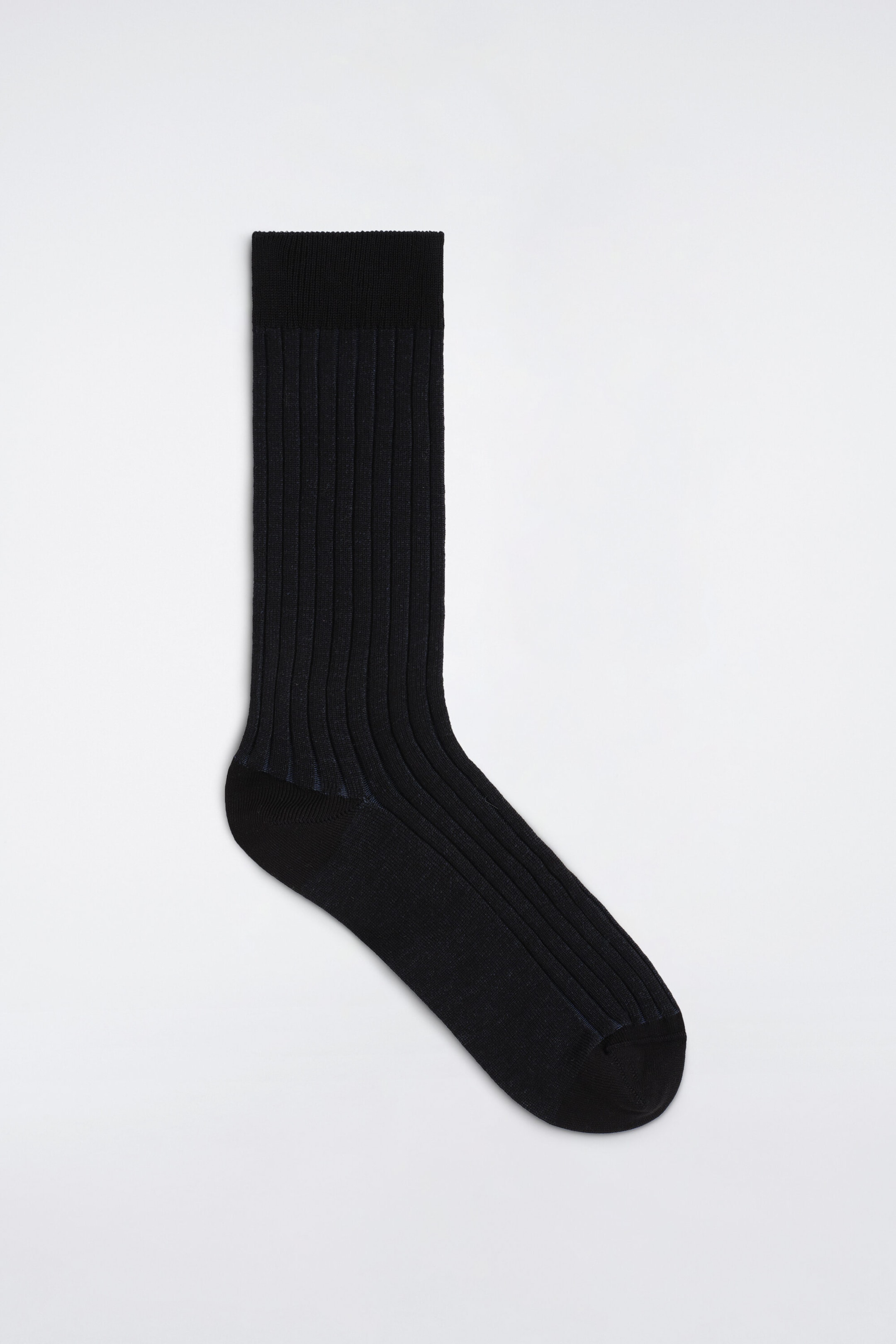 A black sock features a ribbed texture on the leg, a plain-knit foot, and a wide ribbed cuff at the top. A black sock features a ribbed texture on the leg, a plain-knit foot, and a wide ribbed cuff at the top.