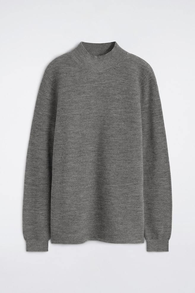 Un pulover gri din lÃ¢nÄ cu guler scurt este prezentat din faÈÄ, avÃ¢nd o texturÄ fin tricotatÄ, un guler Ã®nalt tip mock-neck, mÃ¢neci lungi cu manÈete striate Èi o margine inferioarÄ striatÄ asortatÄ. - 1