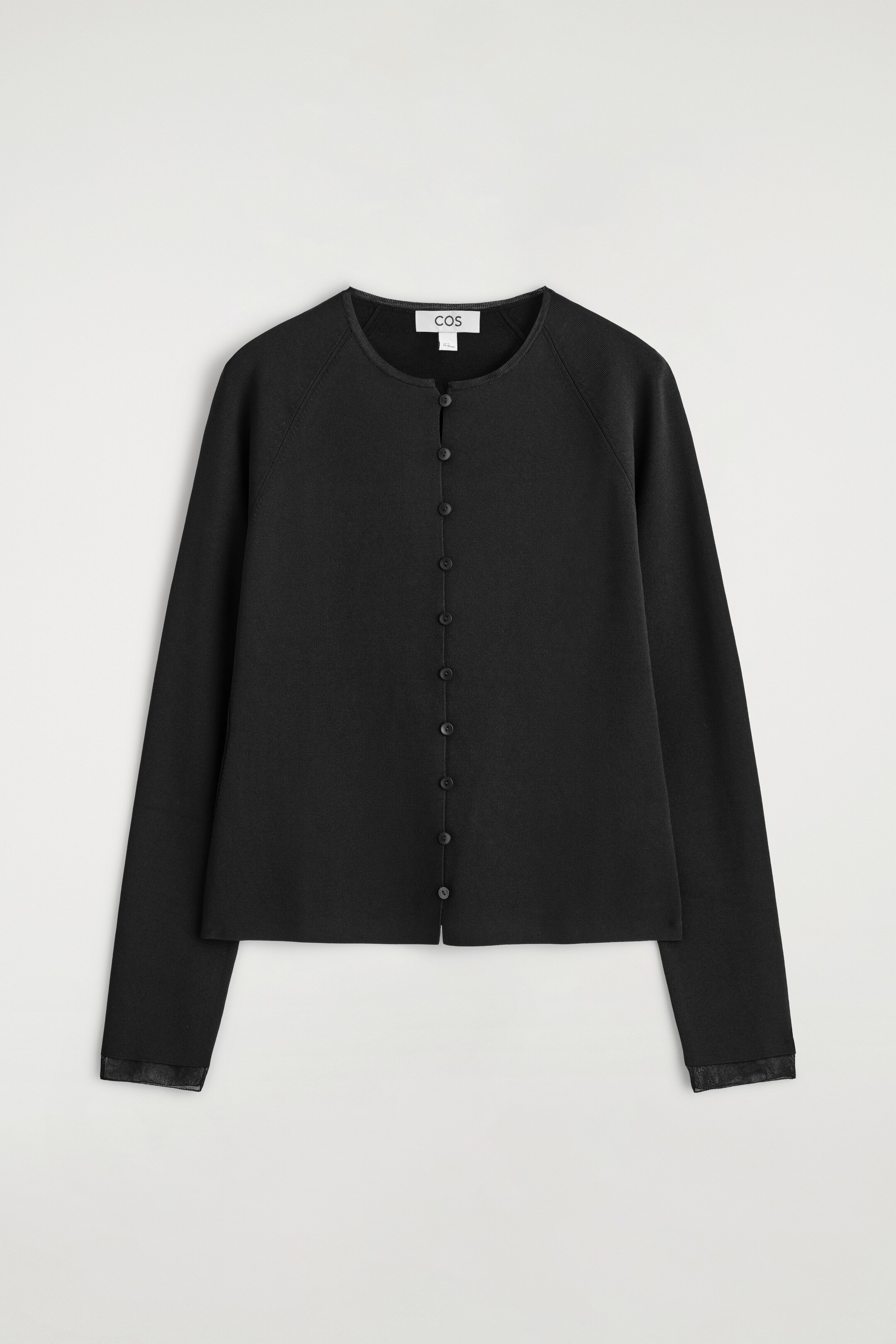 View larger image: A black cardigan is presenting its FRONT view, featuring a round neck and long raglan sleeves. It is showcasing a full button-front closure with small black buttons and faux leather-look trim on the cuffs.
