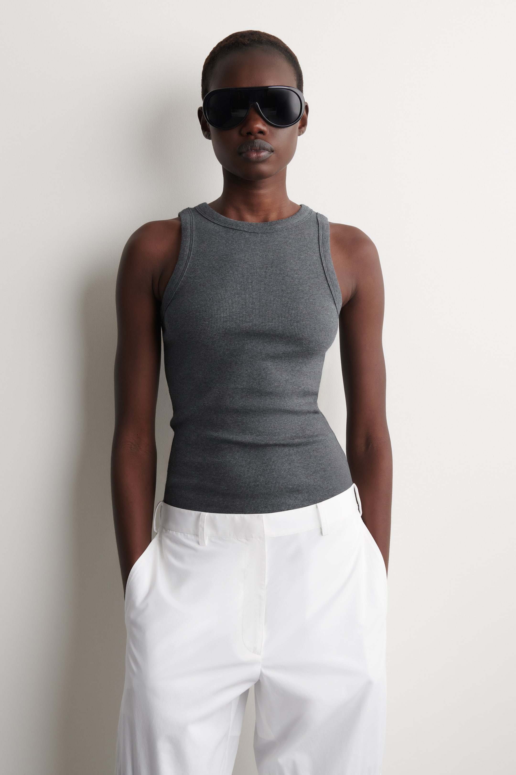 Größeres Bild ansehen: Ein dunkelgraues, geripptes Tanktop ist nach vorne gerichtet, mit einem runden Halsausschnitt und einem figurbetonten Design.