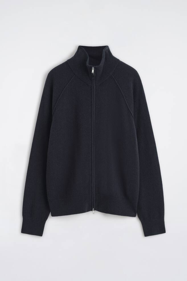 This cashmere funnel-neck zip-up cardigan is shown from the front, featuring a high ribbed collar, raglan sleeves, and a full-length silver-tone zip. The dark navy knitted garment is shown with ribbed cuffs and a matching ribbed hem. - 1