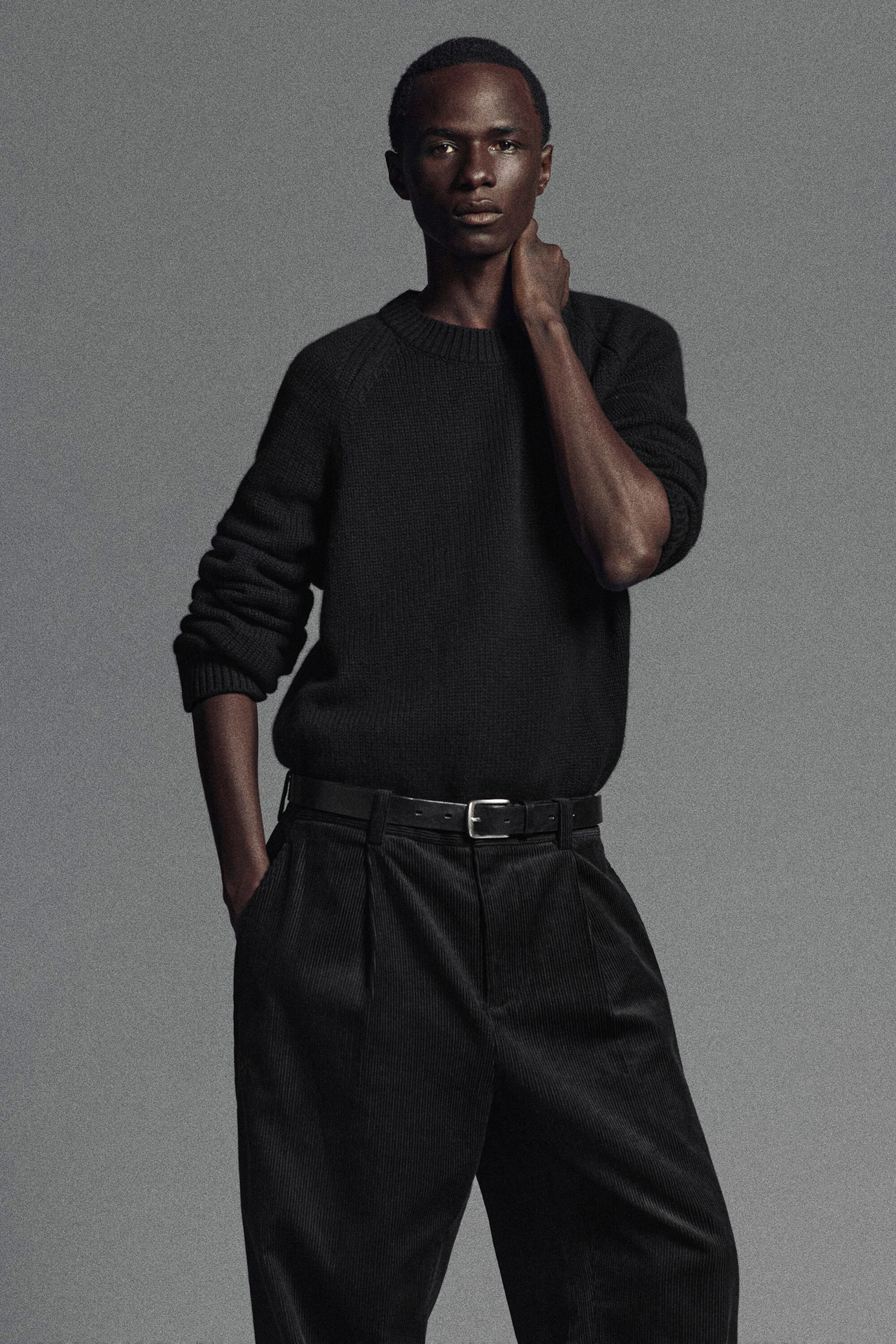 A black chunky cashmere jumper is shown from the front, featuring a thick ribbed crew neck, raglan sleeves, and ribbed cuffs. The relaxed-fit garment drapes softly and is tucked into belted trousers, highlighting its dense, textured knit. A black chunky cashmere jumper is shown from the front, featuring a thick ribbed crew neck, raglan sleeves, and ribbed cuffs. The relaxed-fit garment drapes softly and is tucked into belted trousers, highlighting its dense, textured knit.