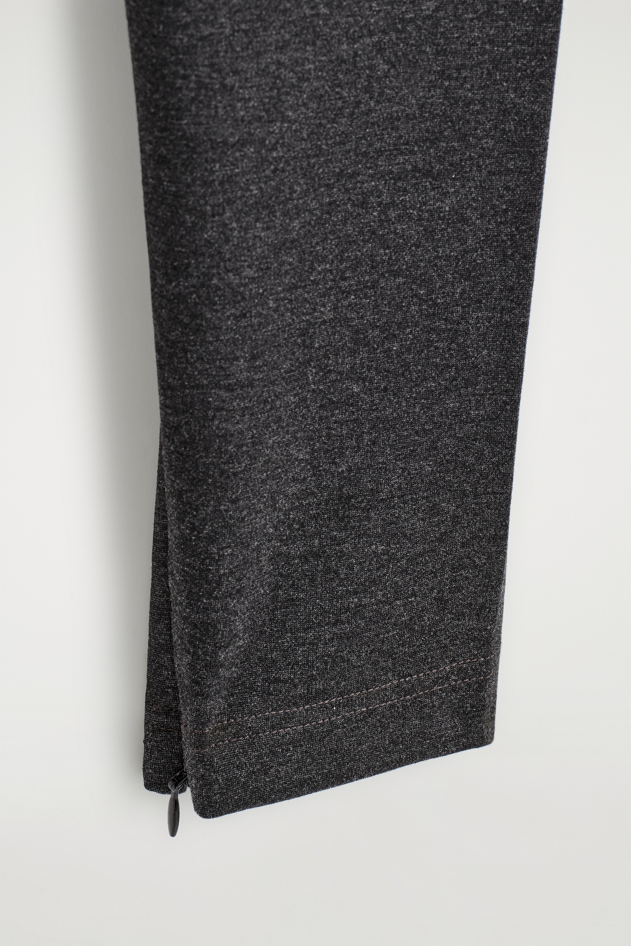 Grotere afbeelding bekijken: RITSMANCHET LEGGINGS. De ONDERKANT van de donkergrijze, gemêleerde leggings toont een aansluitende manchet, met een zwarte ritssluiting langs de zijnaden.