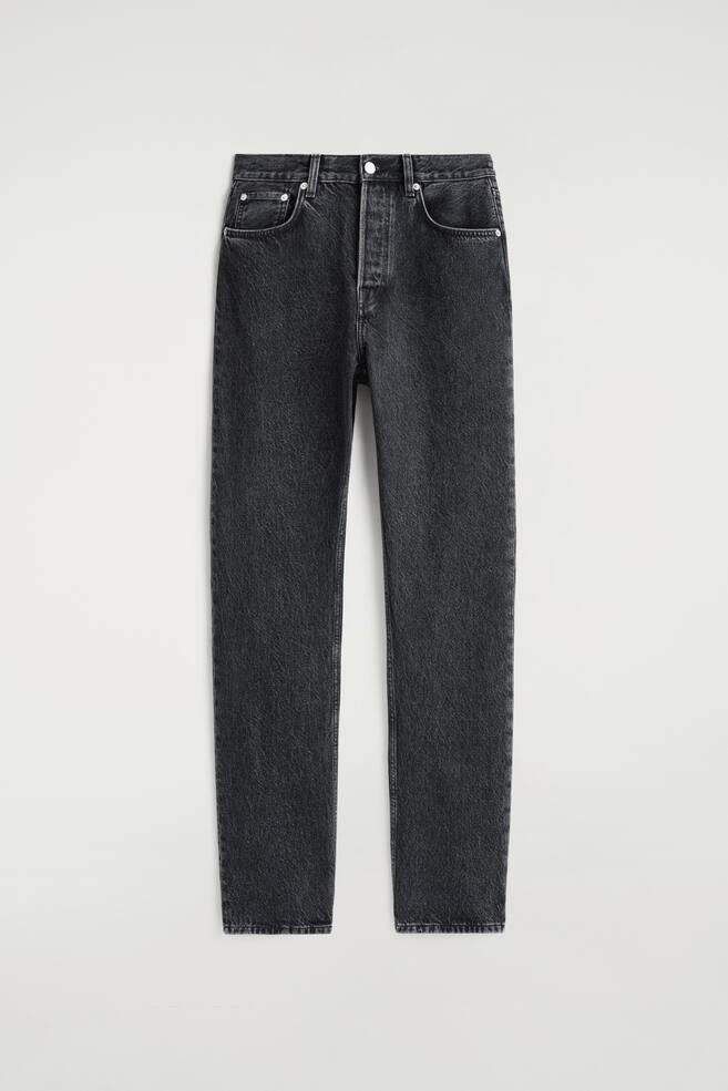 Davanti, un paio di jeans grigio scuro a gamba dritta presenta una vestibilità a vita alta, una chiusura con bottoni e due tasche frontali con rivetti. - 1