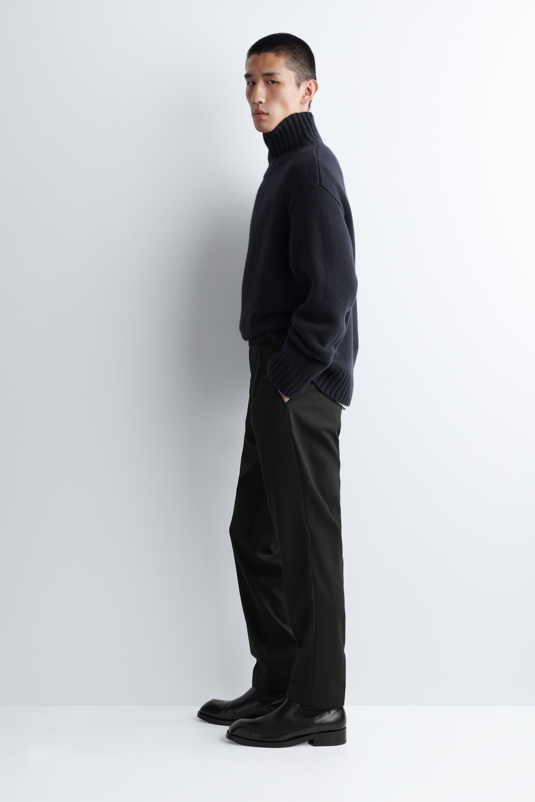 Visualizza immagine più grande: Pantaloni skinny-fit blu navy stanno comparendo dal lato sinistro, aderendo strettamente alle gambe con una consistenza di tessuto liscia. Presentano tasche laterali e si estendono fino alle caviglie.