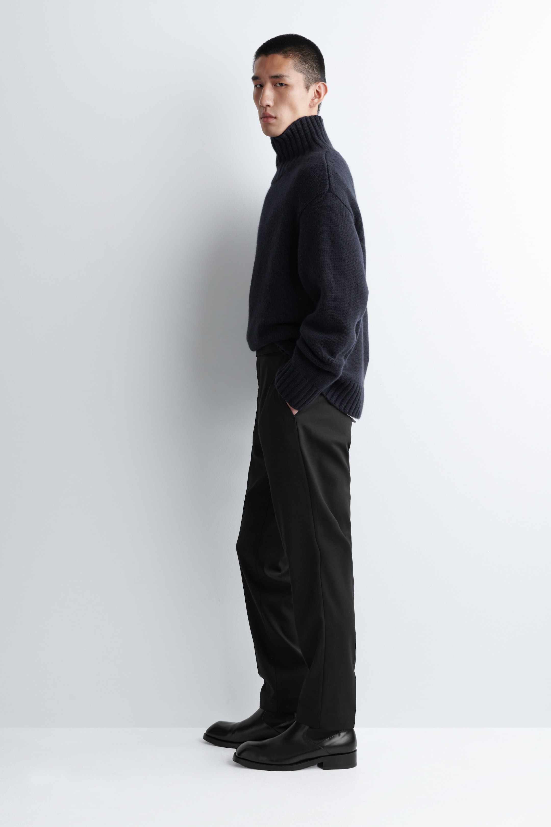 Visualizza immagine più grande: Pantaloni skinny-fit blu navy stanno comparendo dal lato sinistro, aderendo strettamente alle gambe con una consistenza di tessuto liscia. Presentano tasche laterali e si estendono fino alle caviglie.