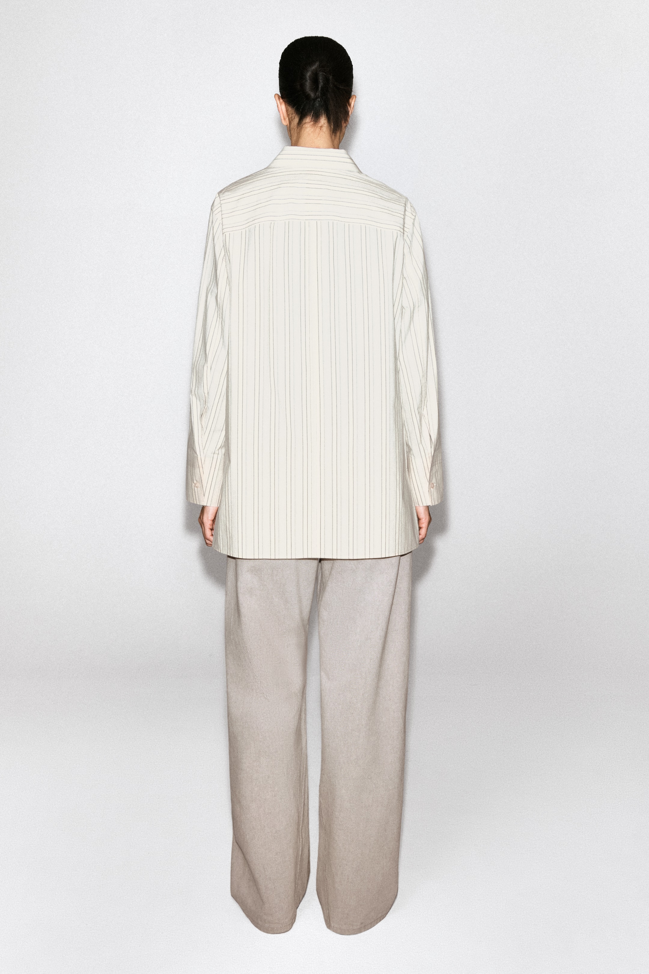View larger image: A regular-fit shirt in buttermilk and grey stripes is shown from the back. It features a clean-cut silhouette with a yoke across the upper back displaying horizontal stripes, while the main body of the shirt has vertical stripes.