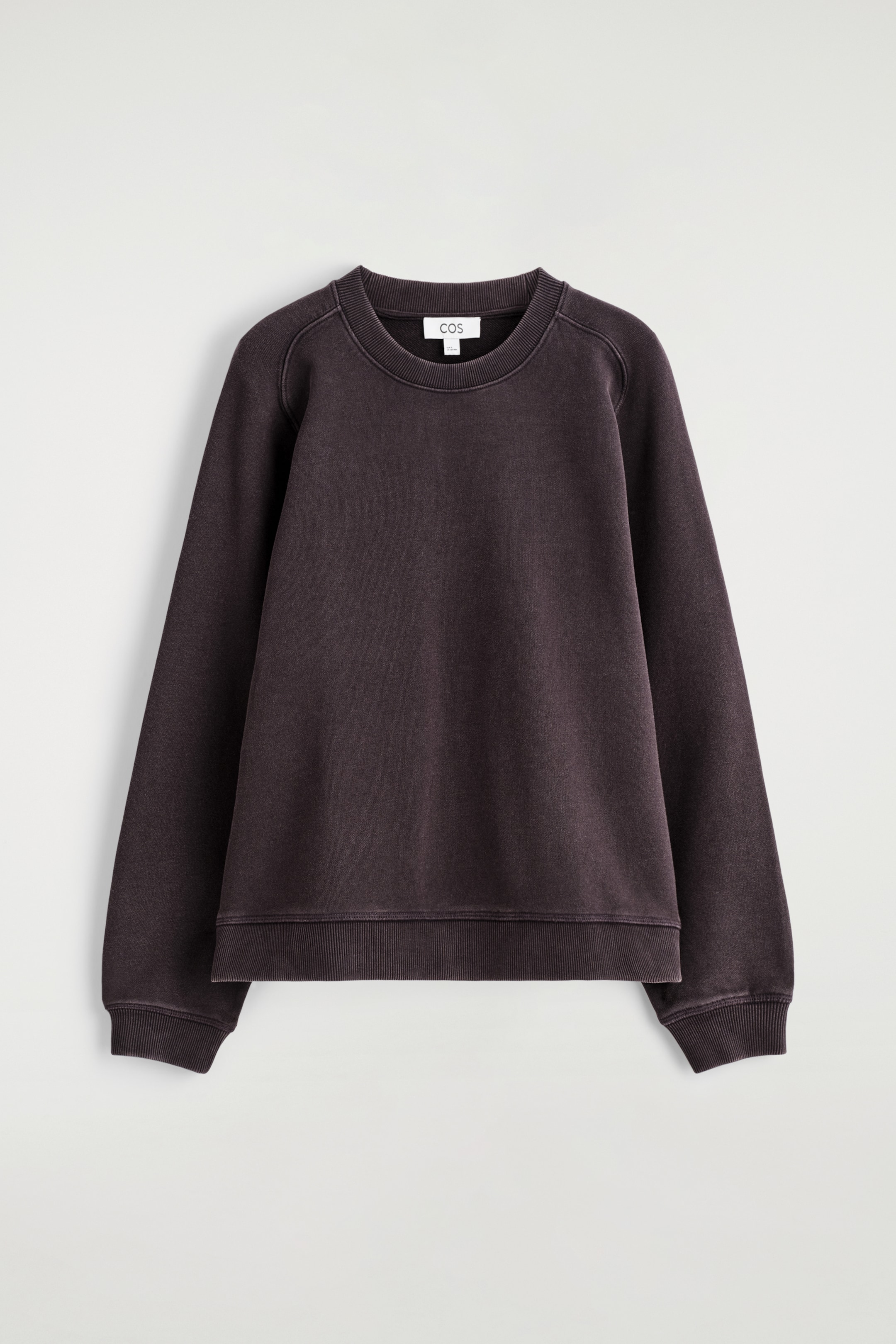 Agrandir l'image: Un sweat-shirt brun foncé est présenté de FACE, avec un col rond, des manches longues avec des coutures raglan visibles, et des finitions côtelées au niveau du col, des poignets et de l'ourlet.