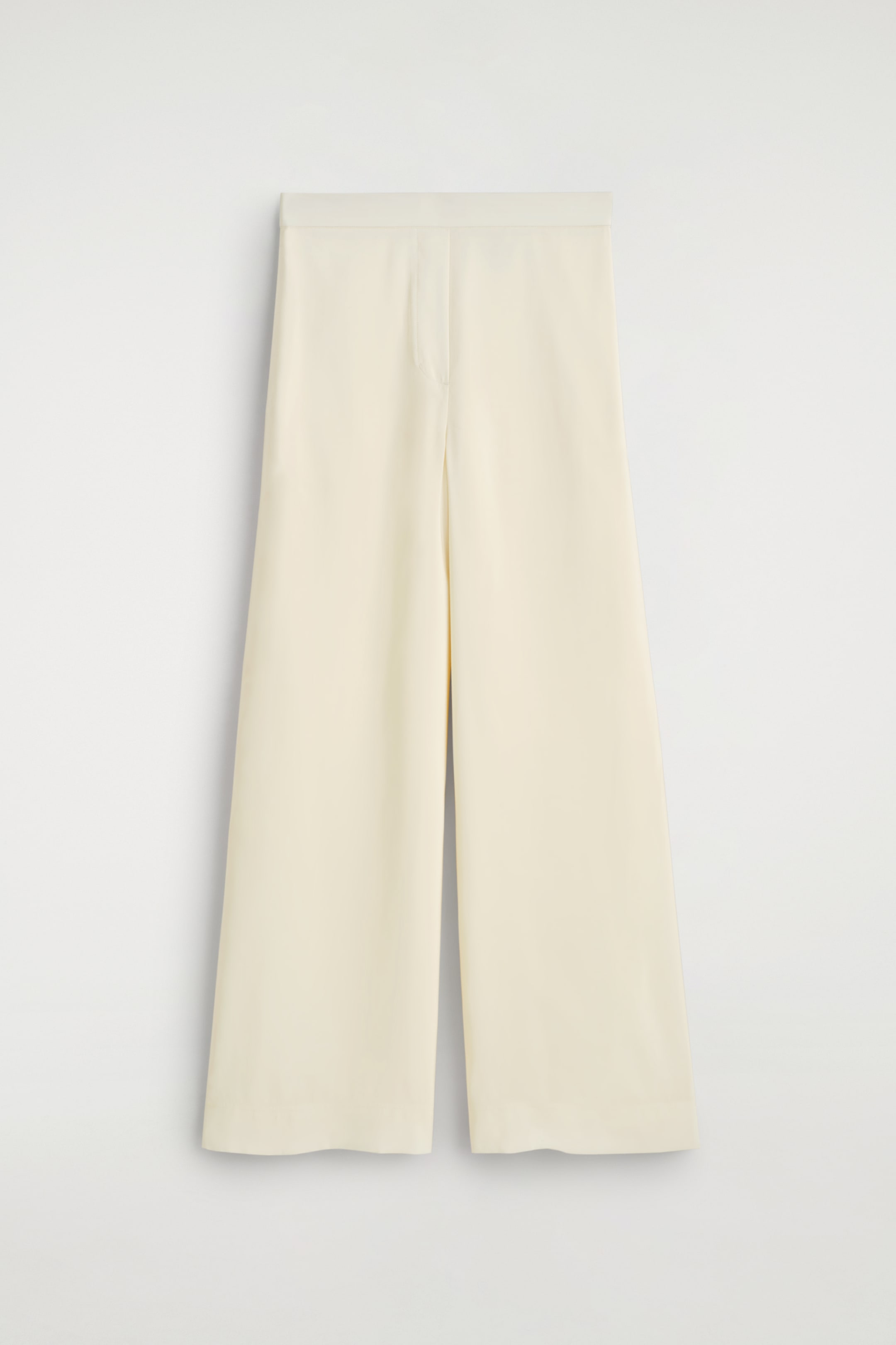 Agrandir l'image: Pantalon large crème faisant face à l'avant, avec une ceinture plate et un éclat subtil sur le tissu. Un pli distinct descend au centre de chaque jambe.