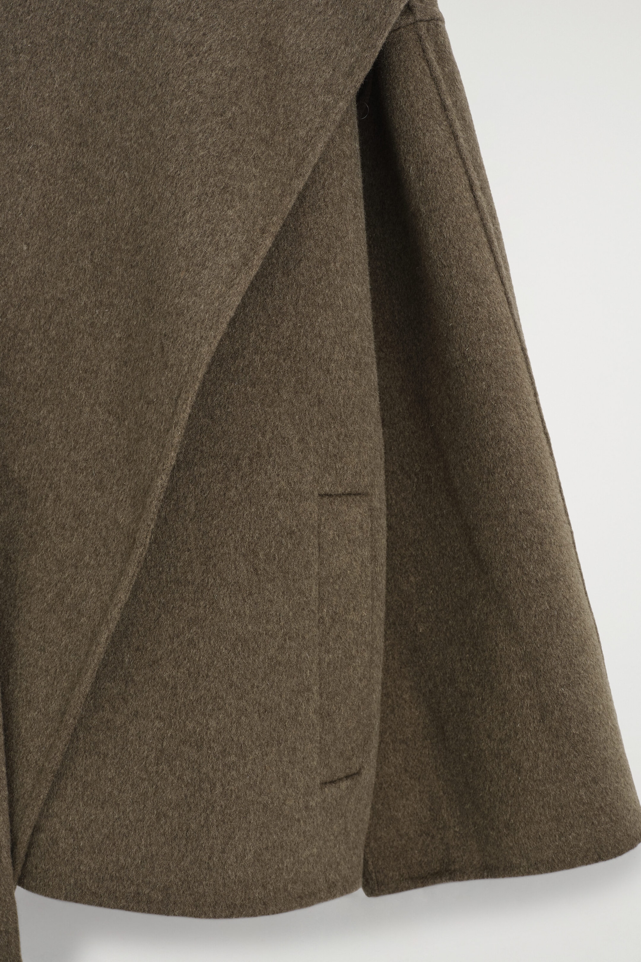 The double-faced wool-blend scarf jacket is shown in a close-up view, highlighting its soft, textured brown fabric, a vertical welt pocket, and a draped front panel. The double-faced wool-blend scarf jacket is shown in a close-up view, highlighting its soft, textured brown fabric, a vertical welt pocket, and a draped front panel.