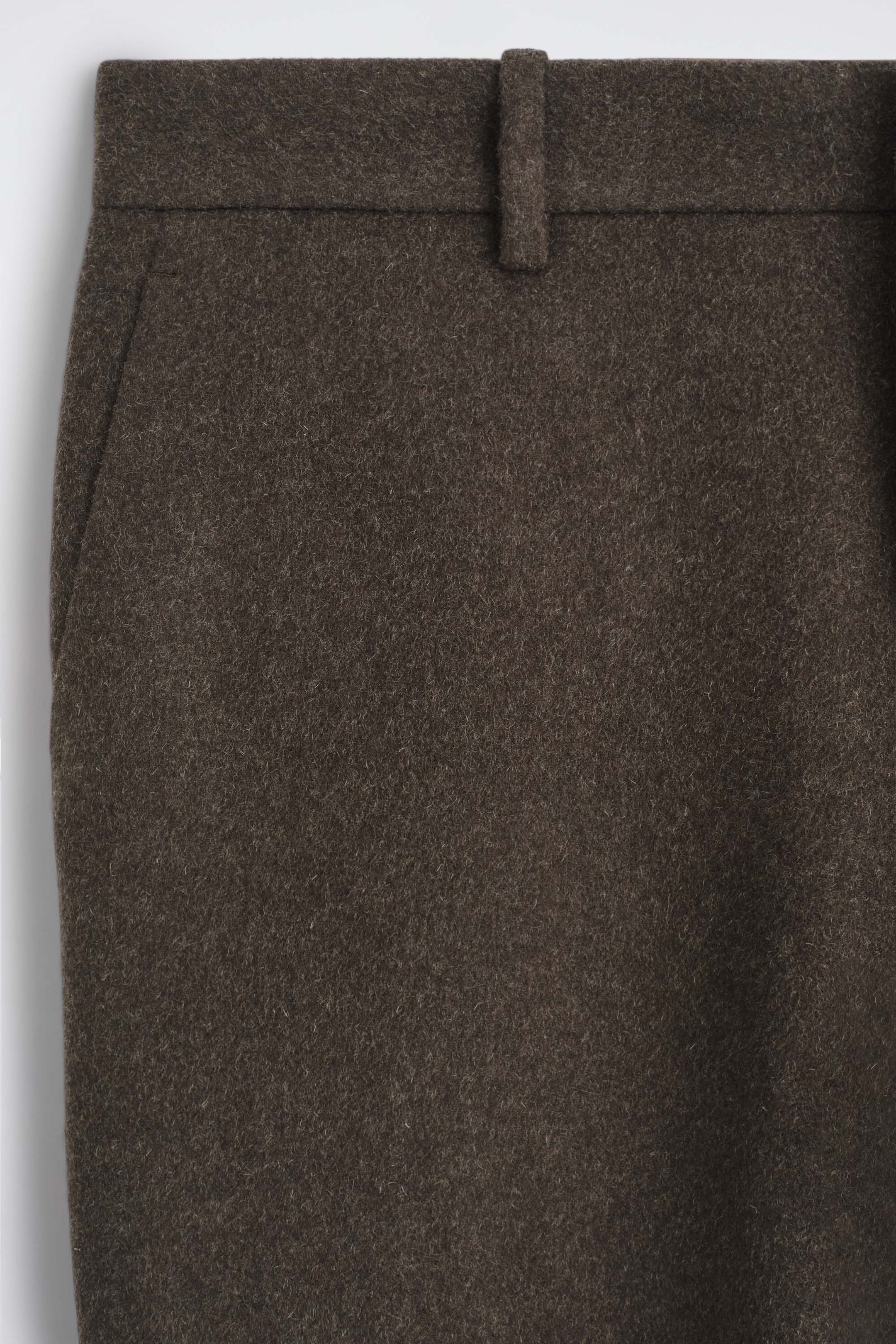 A close-up front view of the double-faced wool-blend straight-leg pants showcases the upper waist and hip area in a textured dark brown fabric. The design features a structured waistband with a single belt loop and a subtle side slit pocket. A close-up front view of the double-faced wool-blend straight-leg pants showcases the upper waist and hip area in a textured dark brown fabric. The design features a structured waistband with a single belt loop and a subtle side slit pocket.