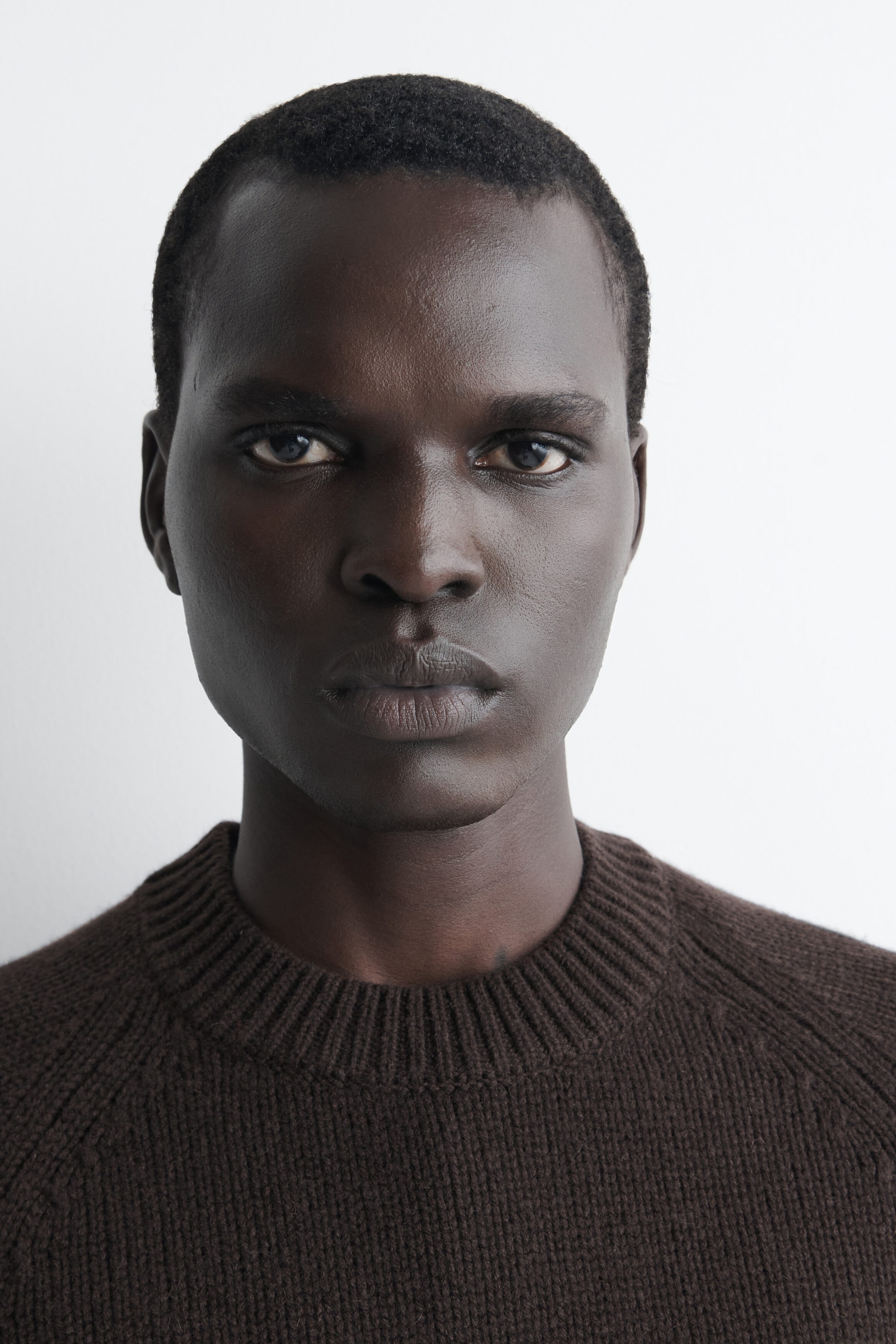 The chunky cashmere jumper in dark brown showcases a ribbed crew neck and raglan shoulder seams in a close-up, front-facing view. The chunky cashmere jumper in dark brown showcases a ribbed crew neck and raglan shoulder seams in a close-up, front-facing view.