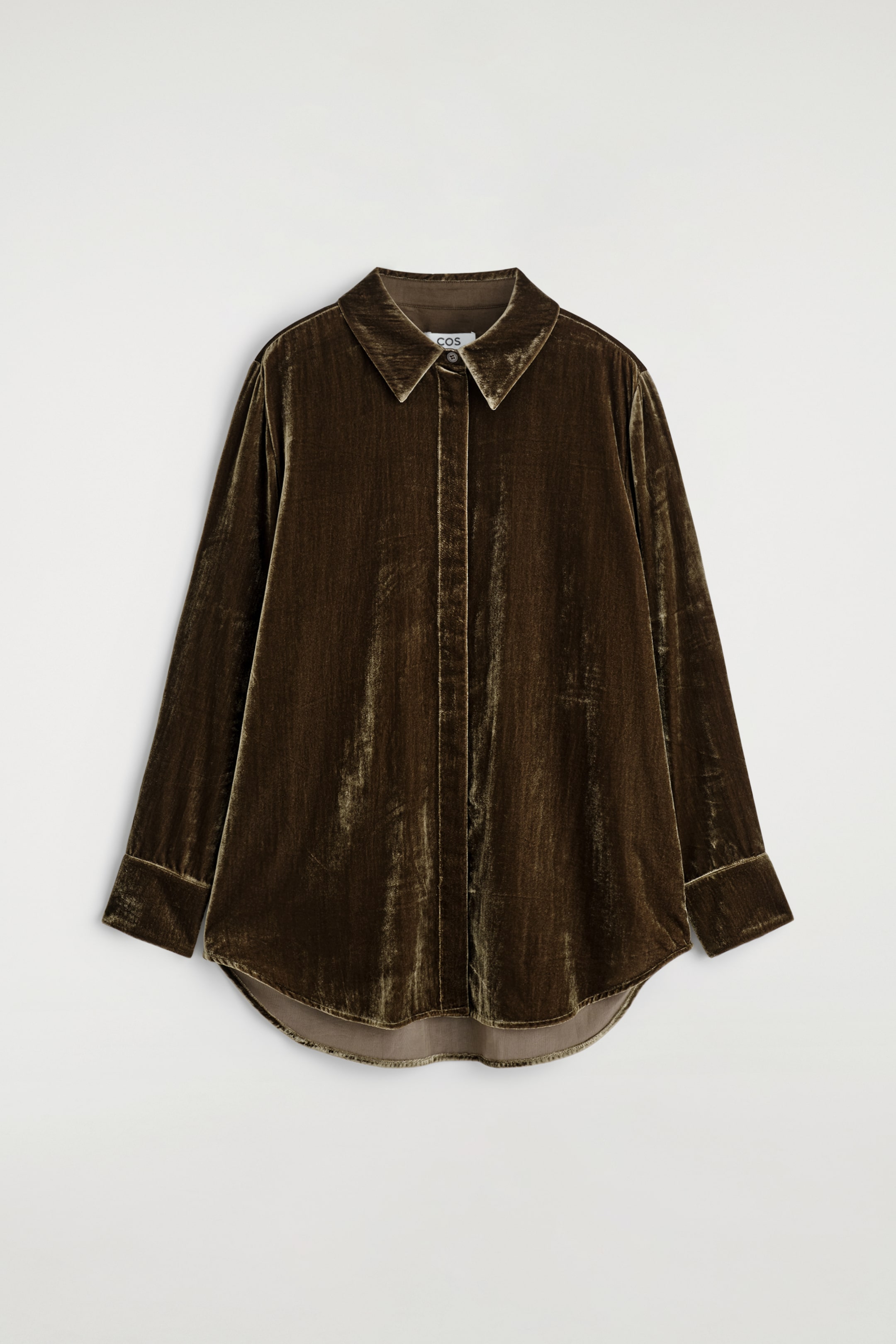 View larger image: A chocolate-toned velvet shirt is facing FRONT, displaying a relaxed silhouette, a pointed collar, a concealed button placket, long sleeves with cuffs, and a curved hem.