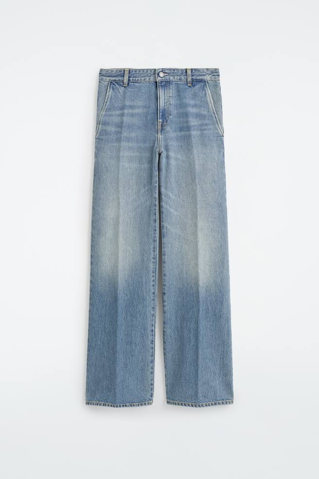 Ein Paar hellblaue Denim-Hosen ist von vorne zu sehen und zeichnet sich durch eine gerade Silhouette mit markanten BÃ¼gelfalten aus, die mittig an jedem Bein verlaufen. Die Hose verfÃ¼gt Ã¼ber einen strukturierten Bund mit GÃ¼rtelschlaufen, seitliche Eingrifftaschen und einen oberen Knopfverschluss. - 1