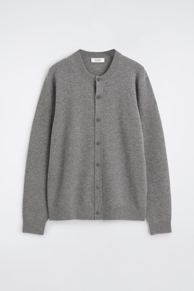 En grÃ¥ cardigan i cashmere vises forfra og har en rund, rund hals, en lodret knaplukning foran og lange Ã¦rmer med ribkanter samt en matchende ribkant forneden. - 1