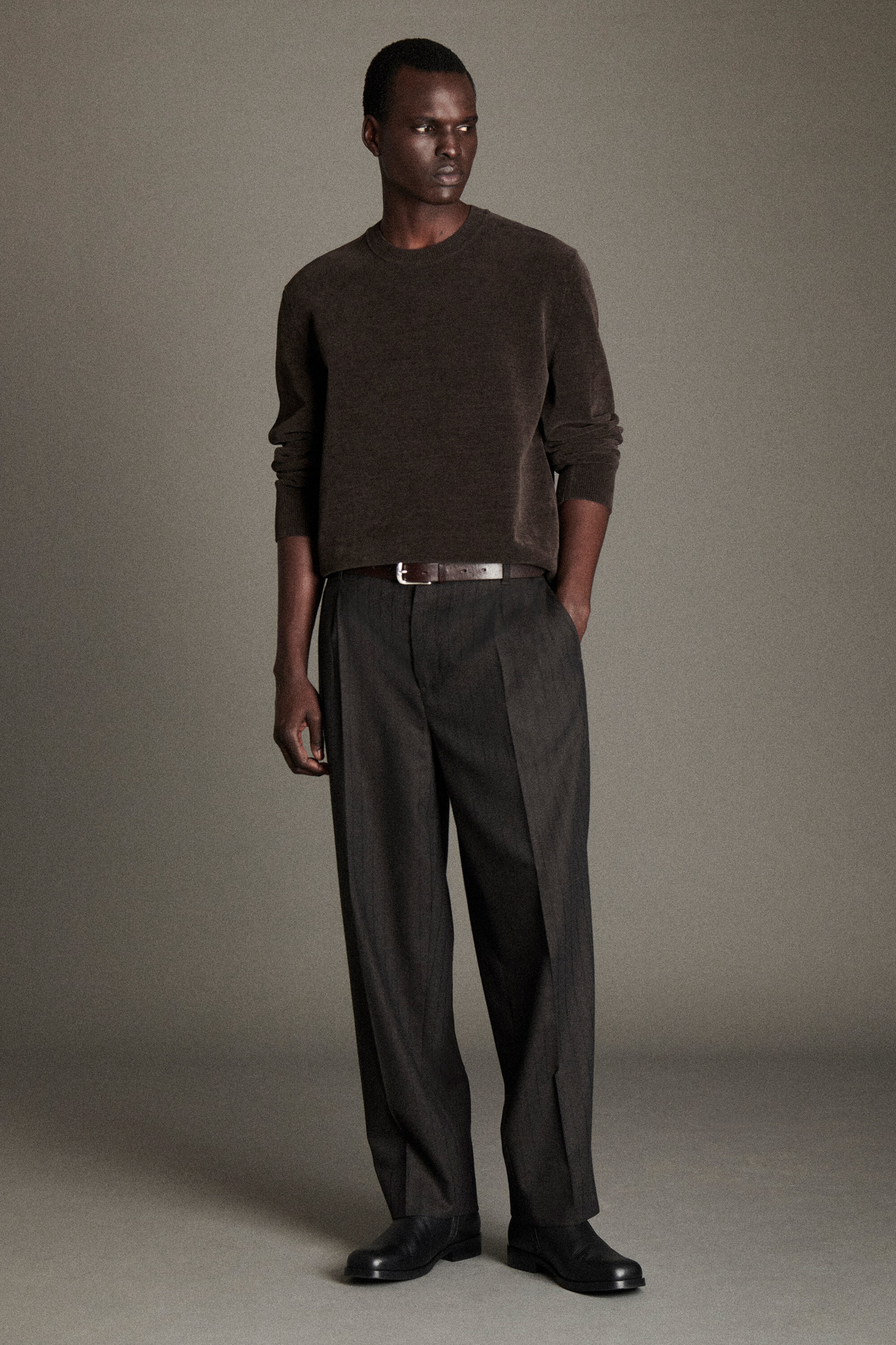 The cotton-chenille crew-neck jumper and pinstriped wool relaxed-fit tapered pants are being styled together in a front view. The dark brown, textured jumper features a crew neck and ribbed cuffs, while the dark grey, pleated pants show a relaxed-fit, tapered silhouette with subtle pinstripes and a creased front. The cotton-chenille crew-neck jumper and pinstriped wool relaxed-fit tapered pants are being styled together in a front view. The dark brown, textured jumper features a crew neck and ribbed cuffs, while the dark grey, pleated pants show a relaxed-fit, tapered silhouette with subtle pinstripes and a creased front.