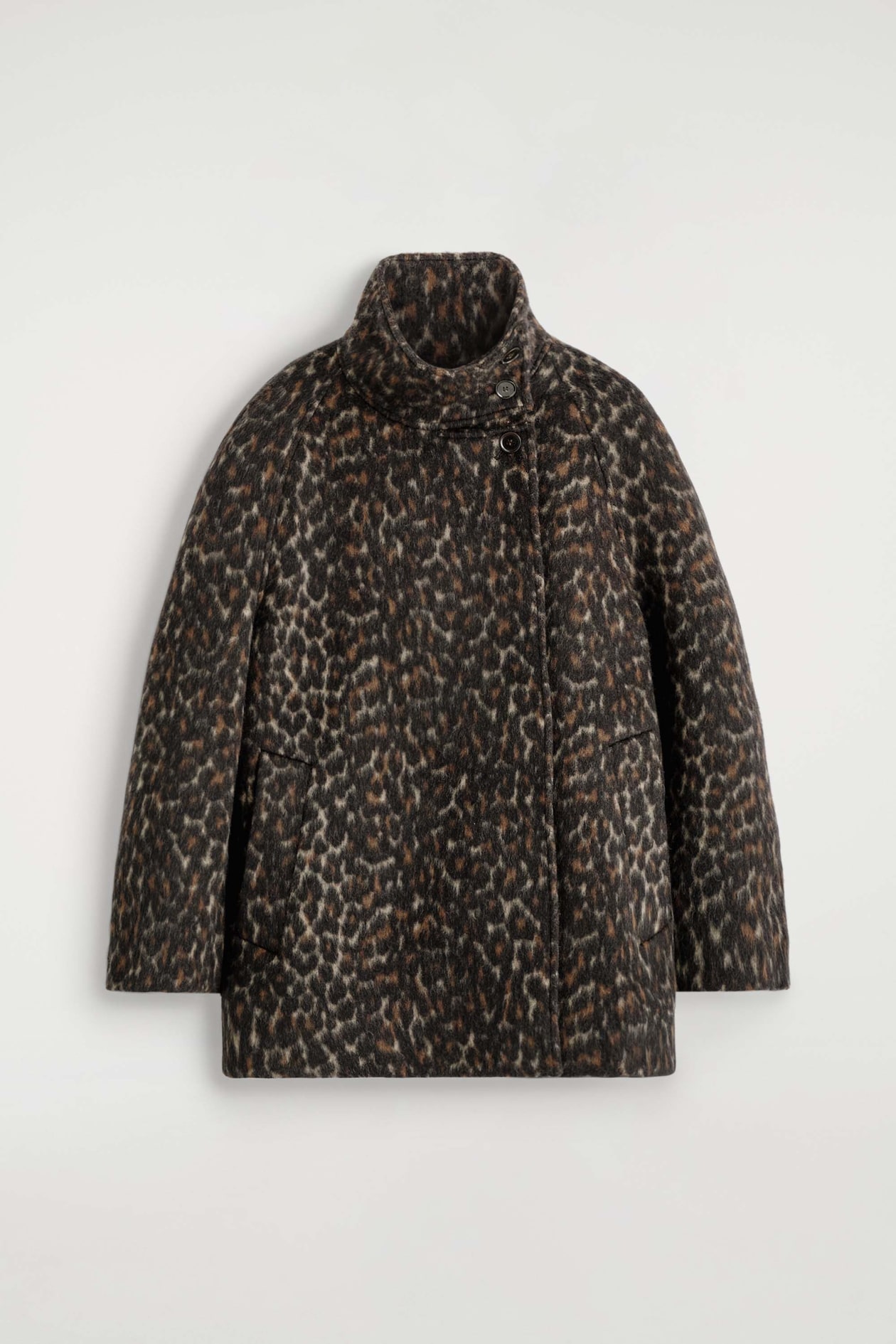 Ein Mantel aus Wollmischung mit Leopardenprint ist frontal dargestellt und zeigt einen hohen Stehkragen mit asymmetrischem Knopfverschluss. Das Kleidungsstück weist eine flauschige Textur mit einem durchgängigen Leopardenmuster in dunklen Tönen, Raglanärmel und dezente seitliche Leistentaschen auf.