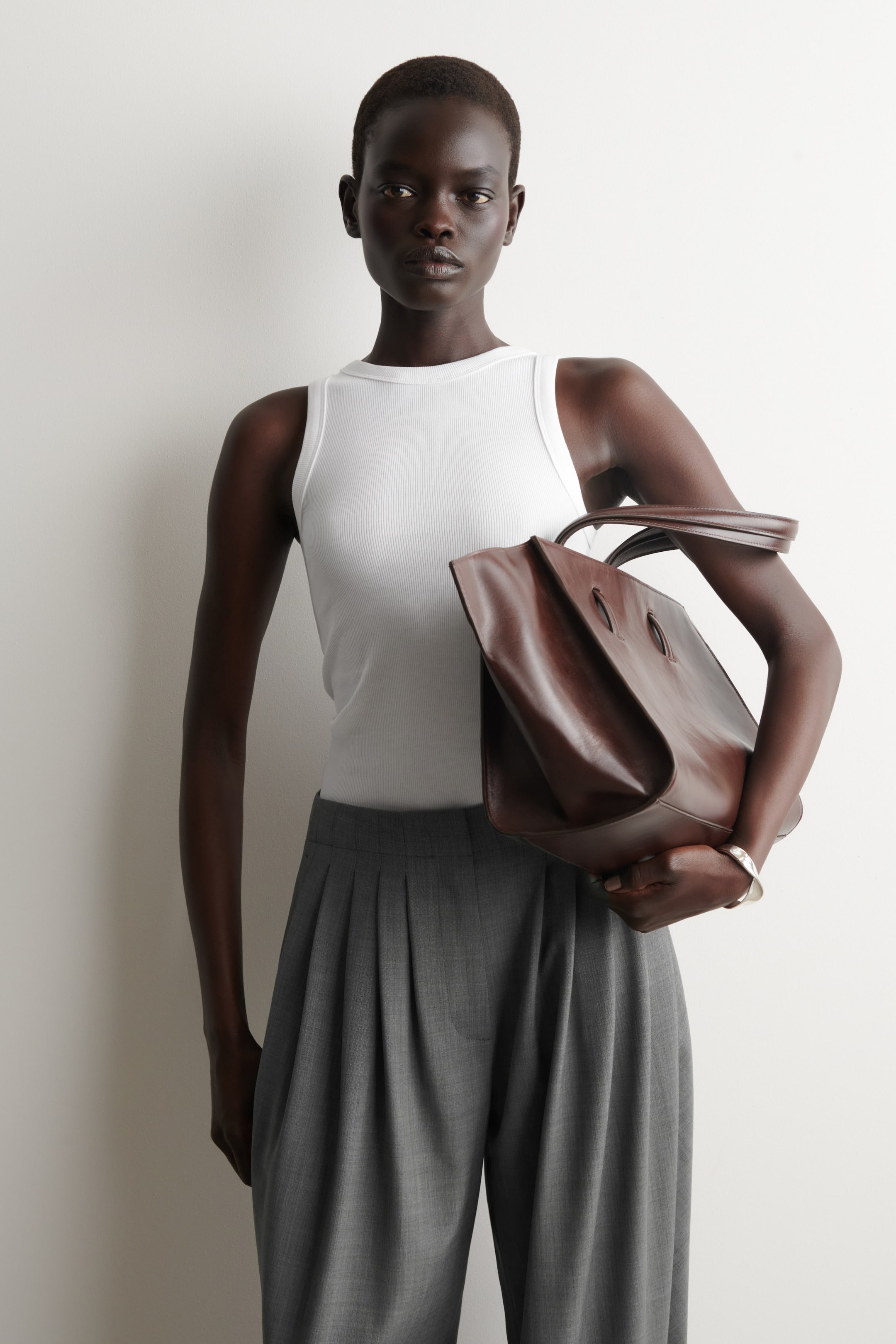 Vis større bilde: En hvit ribbestrikket tanktopp er frontvendt, med en rund halslinje og en tettsittende, ribbestrikket tekstur.