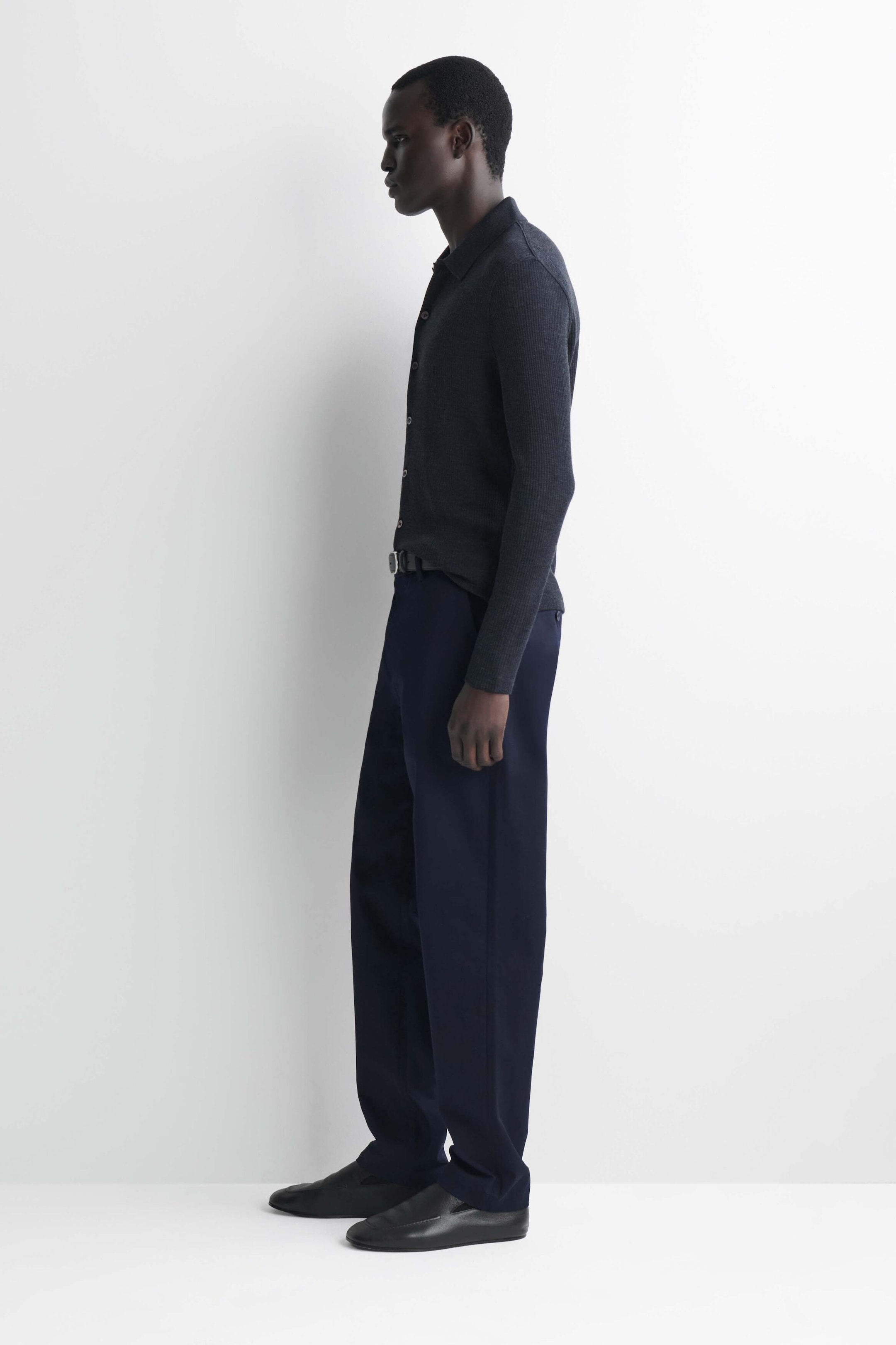 I chinos slim fit a gamba dritta in cotone blu navy sono mostrati di profilo laterale, rivolti verso sinistra, mettendo in evidenza la loro silhouette pulita e dritta. I pantaloni presentano un girovita strutturato, abbinato a una camicia grigio scuro infilata all’interno e a una cintura nera, con l’orlo che cade ordinatamente sopra scarpe nere in pelle. I chinos slim fit a gamba dritta in cotone blu navy sono mostrati di profilo laterale, rivolti verso sinistra, mettendo in evidenza la loro silhouette pulita e dritta. I pantaloni presentano un girovita strutturato, abbinato a una camicia grigio scuro infilata all’interno e a una cintura nera, con l’orlo che cade ordinatamente sopra scarpe nere in pelle.