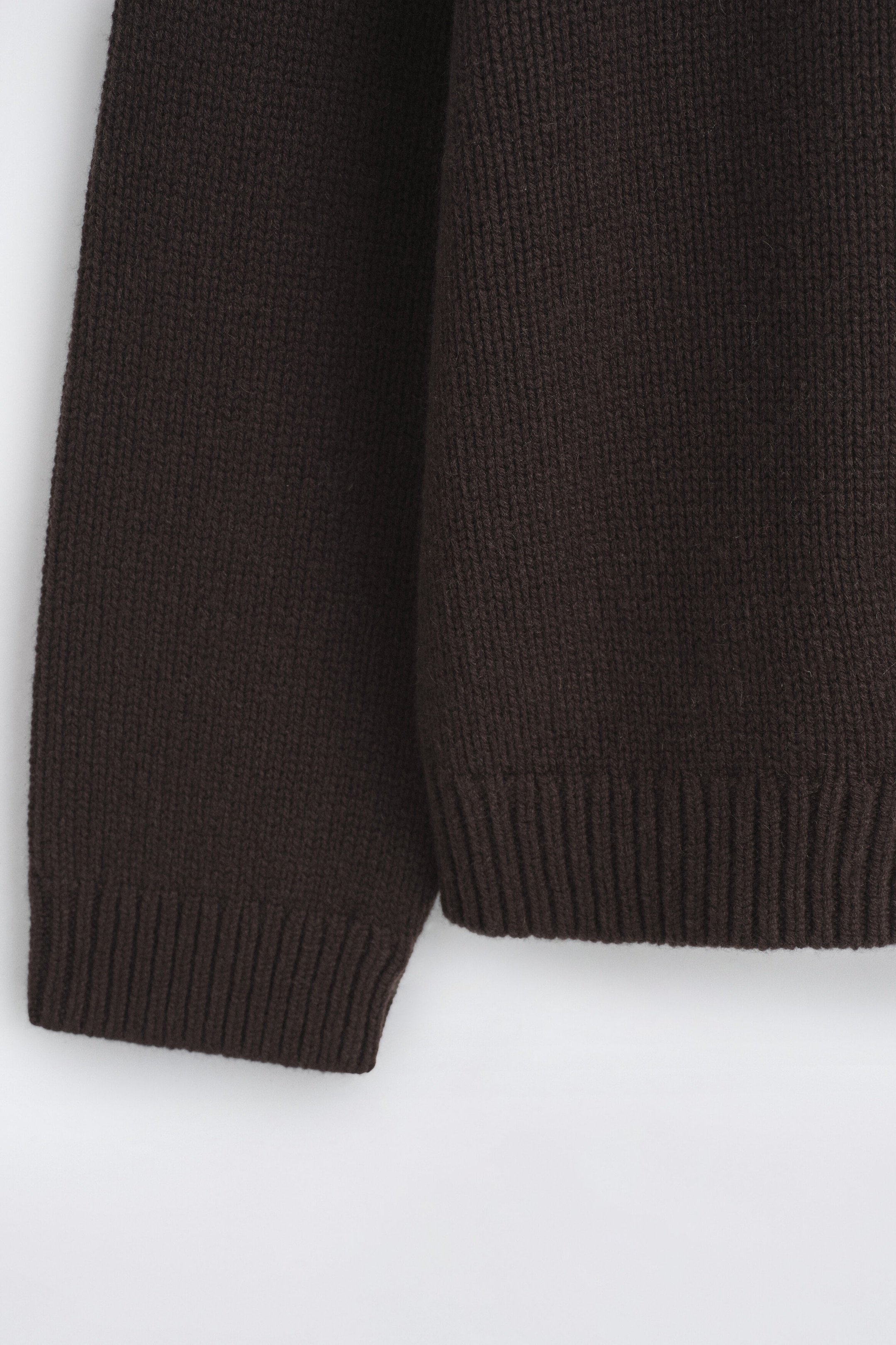 The chunky cashmere sweater in dark brown is shown in a close-up front view, highlighting its thick, textured knit fabric, along with the ribbed hem and matching ribbed sleeve cuff. The chunky cashmere sweater in dark brown is shown in a close-up front view, highlighting its thick, textured knit fabric, along with the ribbed hem and matching ribbed sleeve cuff.