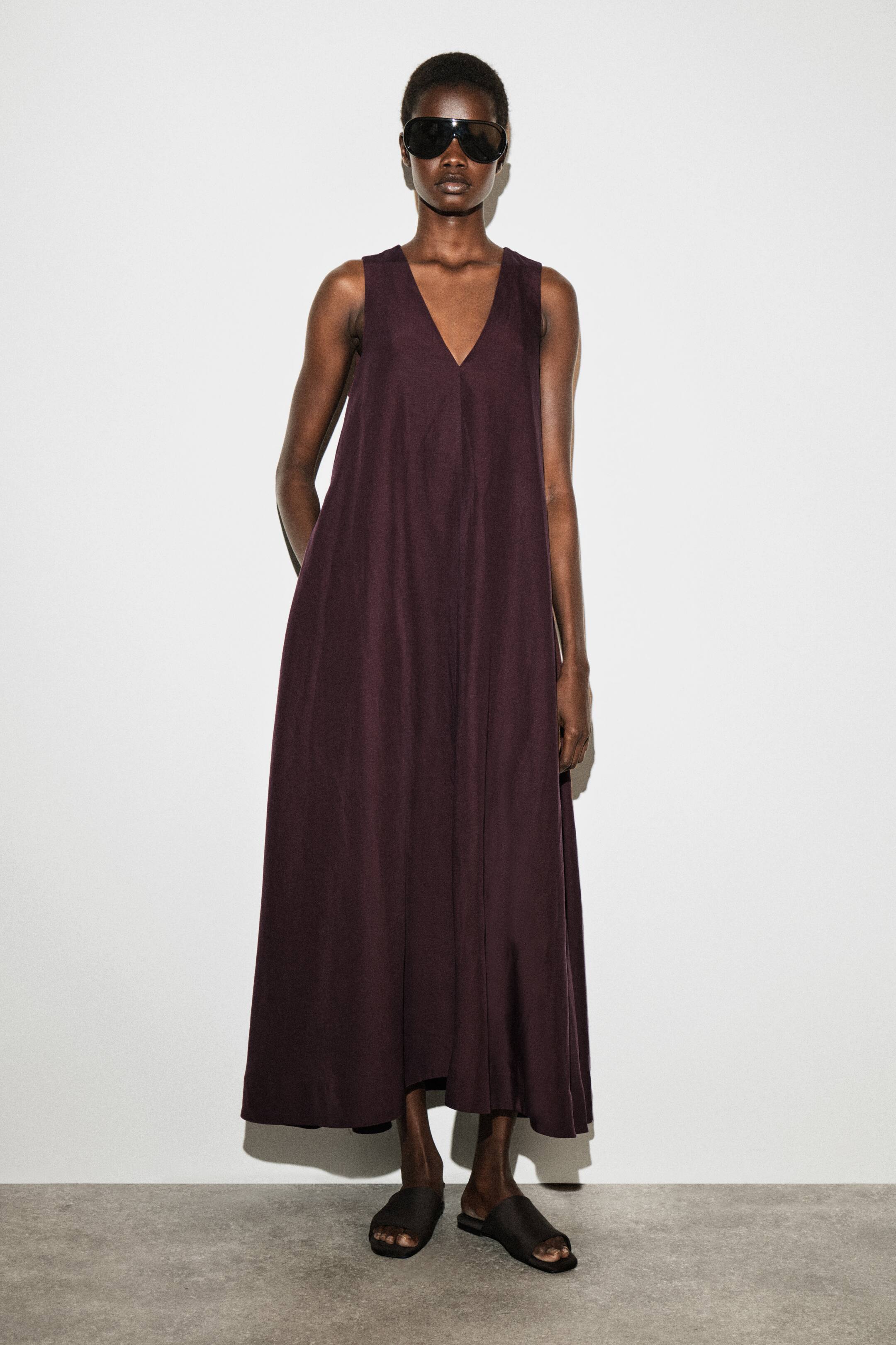 View larger image: A deep plum maxi dress featuring a V-neckline and a sleeveless design, flowing loosely to the ankles.