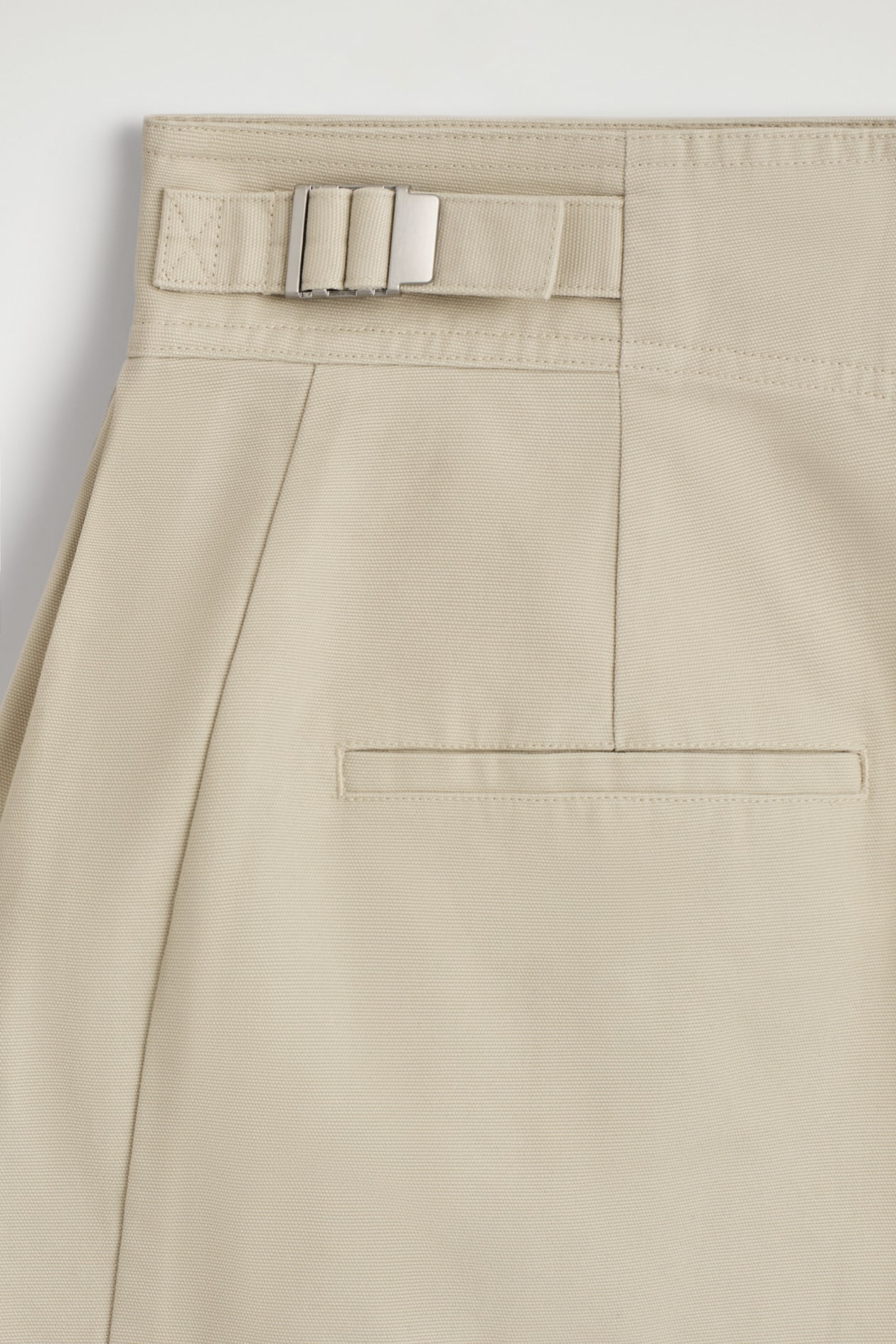 PLEATED BUCKLE-DETAIL MINI SKIRT — LIGHT BEIGE