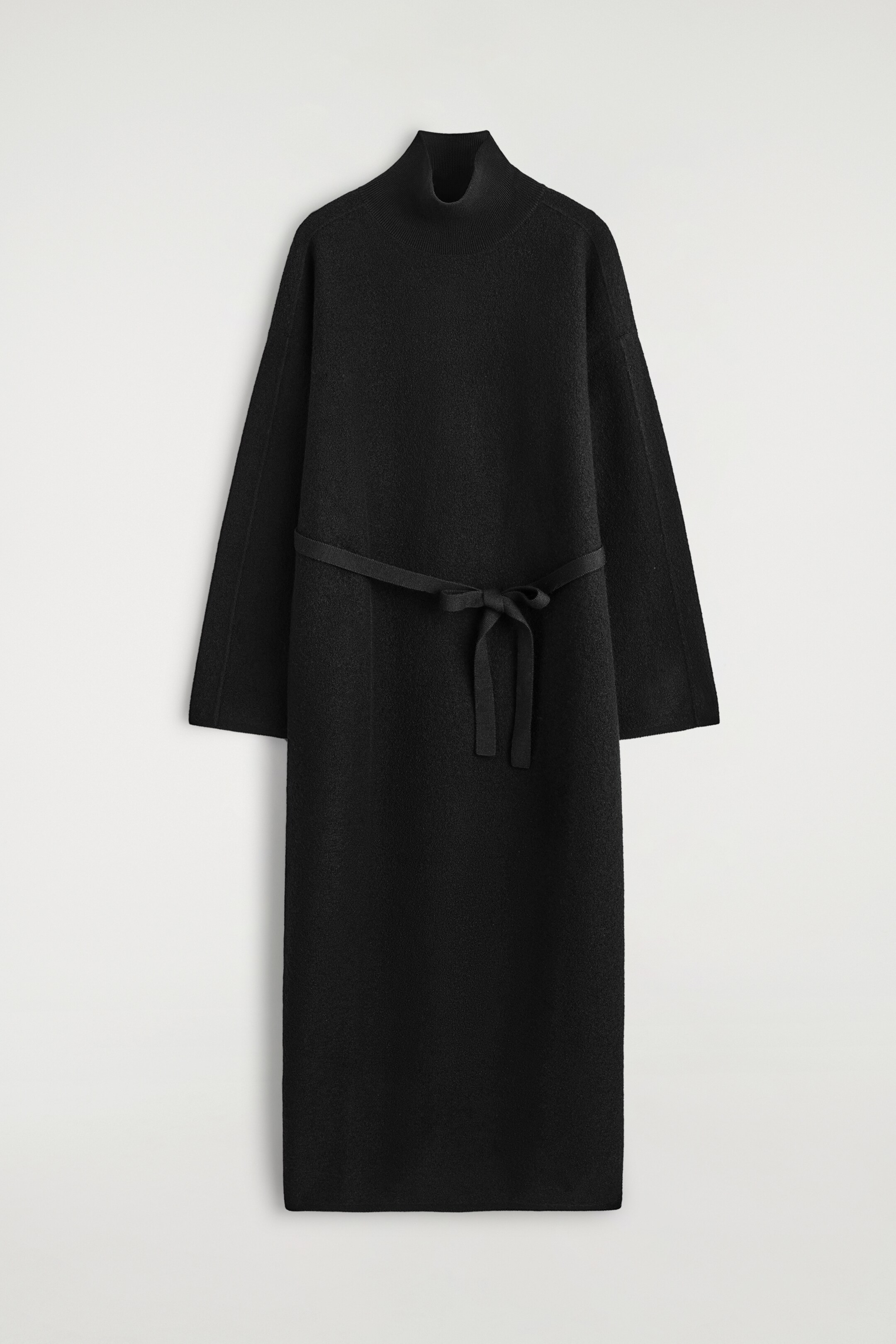 Ver imagen más grande: Un vestido negro con cuello embudo se muestra desde el frente, con un material texturizado, mangas largas y anchas, y un cinturón autoajustable anudado en la cintura.